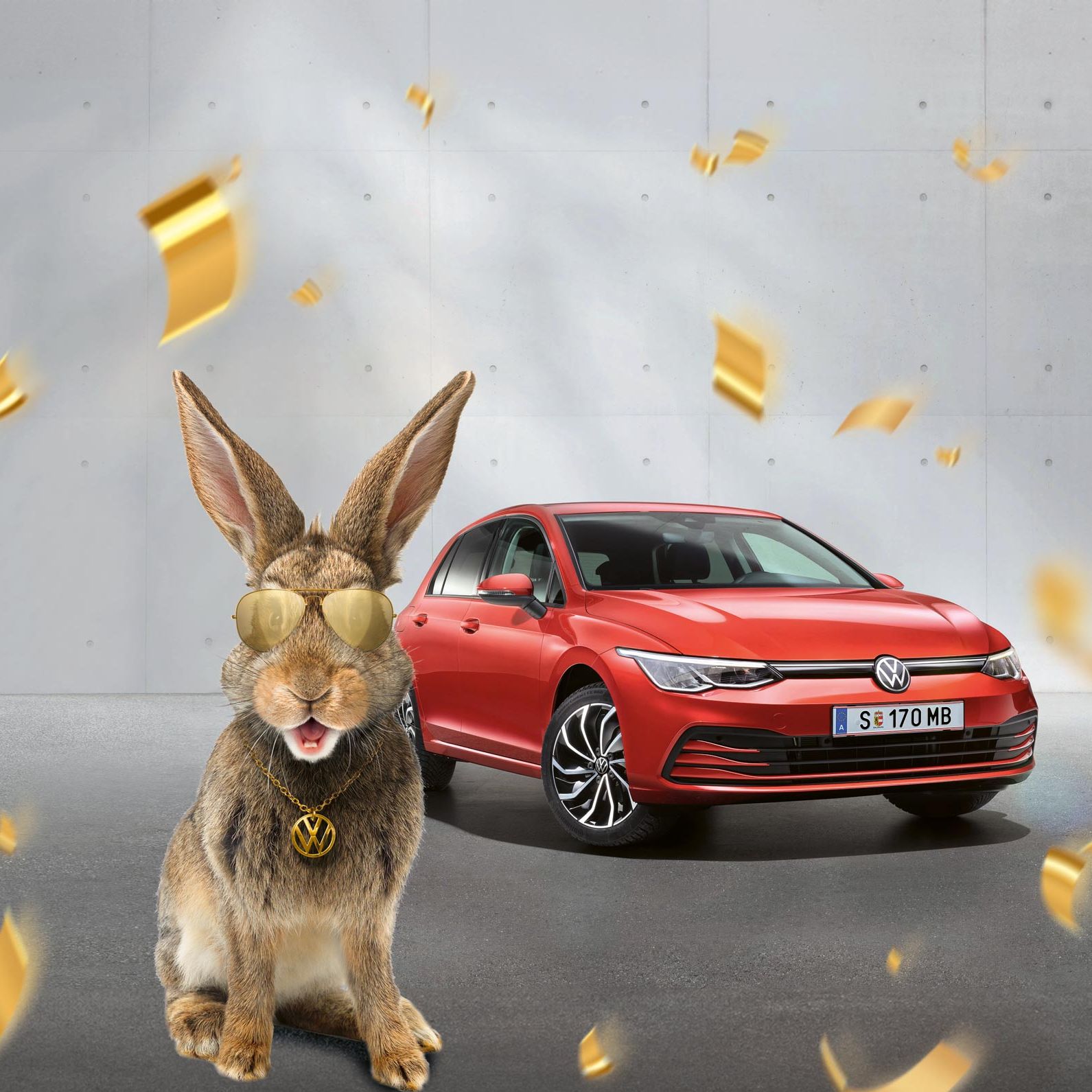Червен Volkswagen Golf с великденски заек, носещ златни очила и медальон с логото на Volkswagen, заобиколен от падащи златни конфети