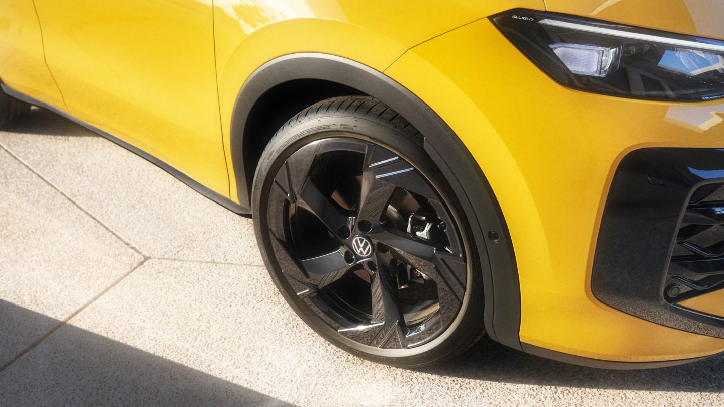 Жълт Volkswagen с детайл на предна джанта и фарове.