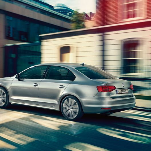 Сребрист Volkswagen Jetta в движение по градска улица