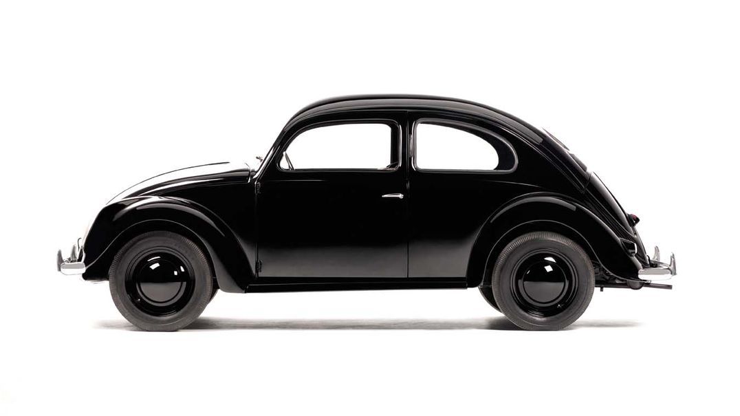 Страничен изглед на ретро черен Volkswagen Beetle върху бял фон