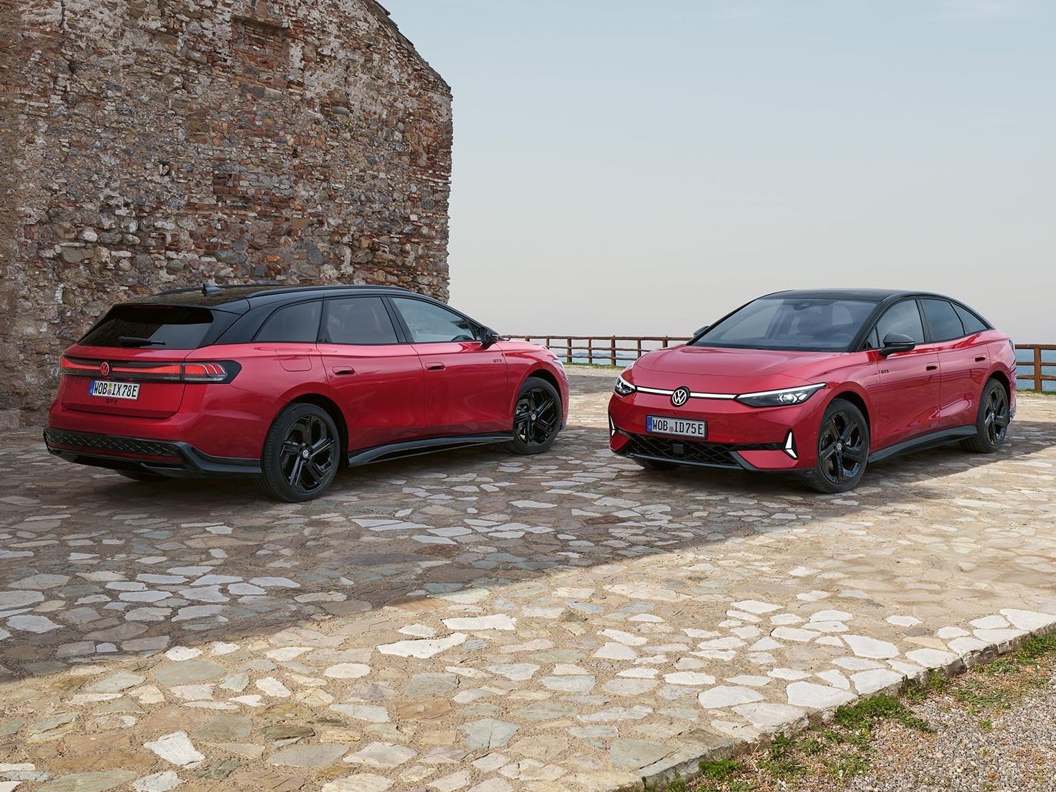 Volkswagen ID.7 Tourer и ID.7 в червен и сив цвят, паркирани край морето под палма