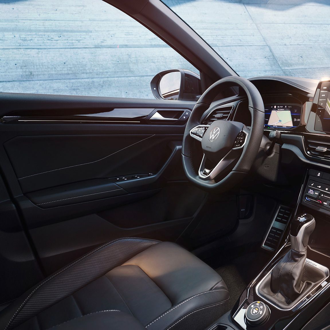 VW T-Roc Interieur, Sicht vom Beifahrersitz auf Fahrersitz und Cockpit mit Multifunktionslenkrad und Infotainment-System