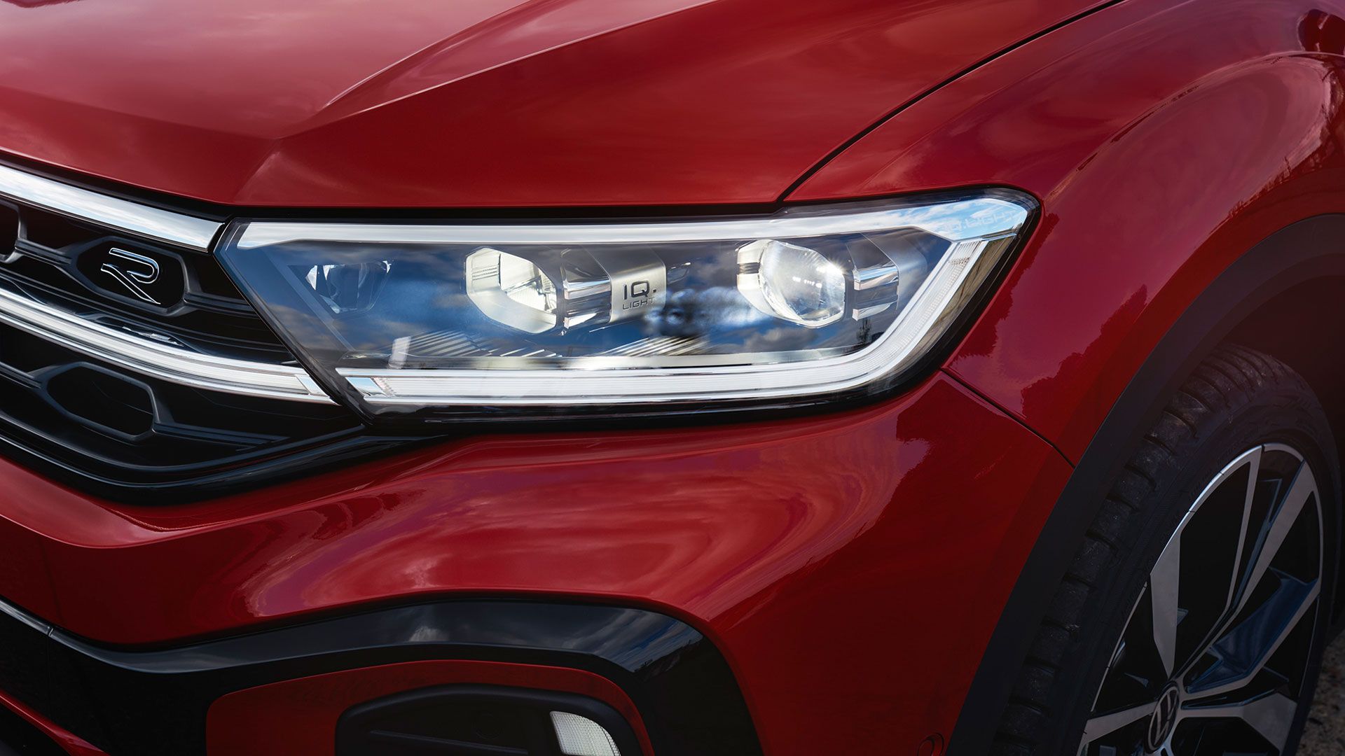 Детайлен поглед към десния фар IQ.LIGHT на VW T-Roc Cabriolet в червен цвят.