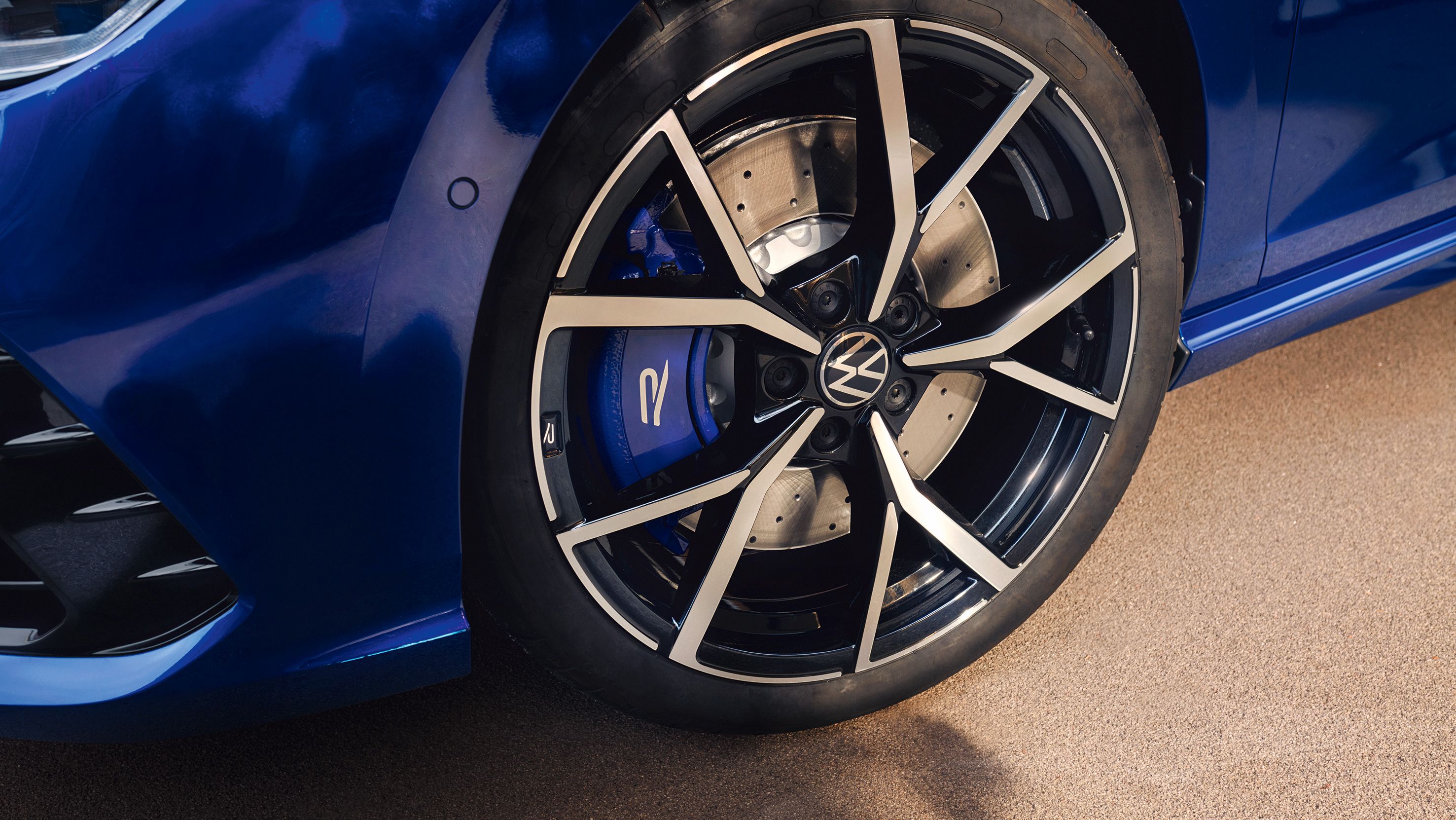 Близък план на предна алуминиева джанта на син Volkswagen Golf R с R спирачни апарати