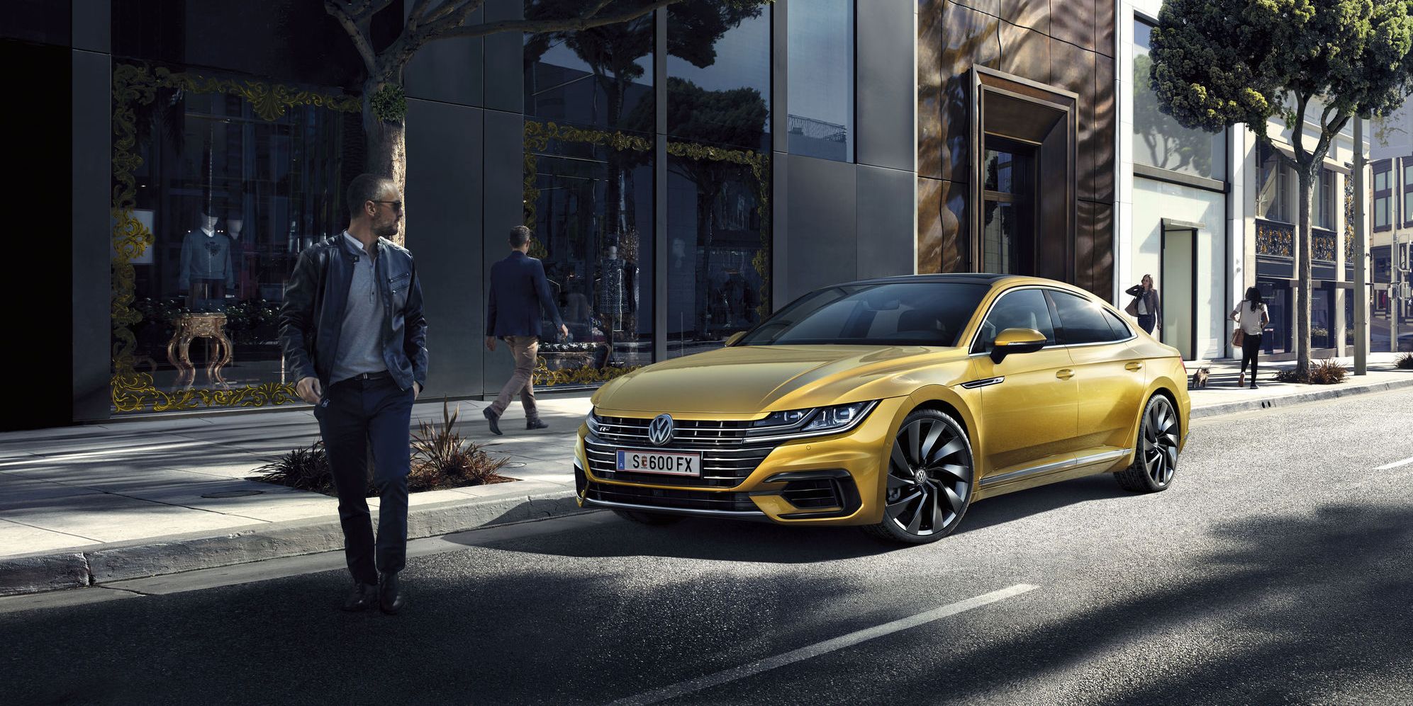 Стилен златист Volkswagen Arteon Shooting Brake паркиран на модерна градска улица
