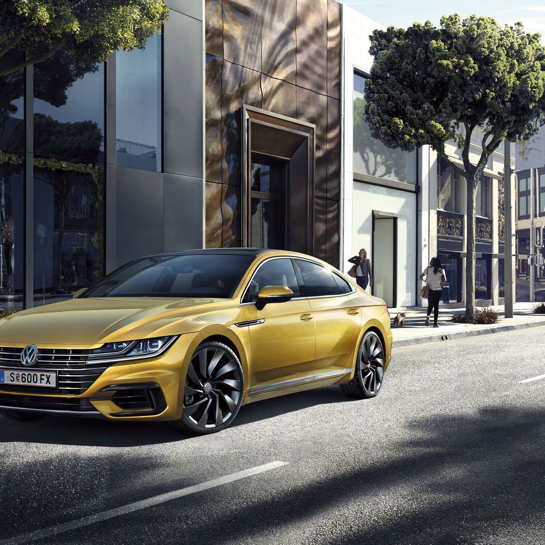Стилен златист Volkswagen Arteon Shooting Brake паркиран на модерна градска улица