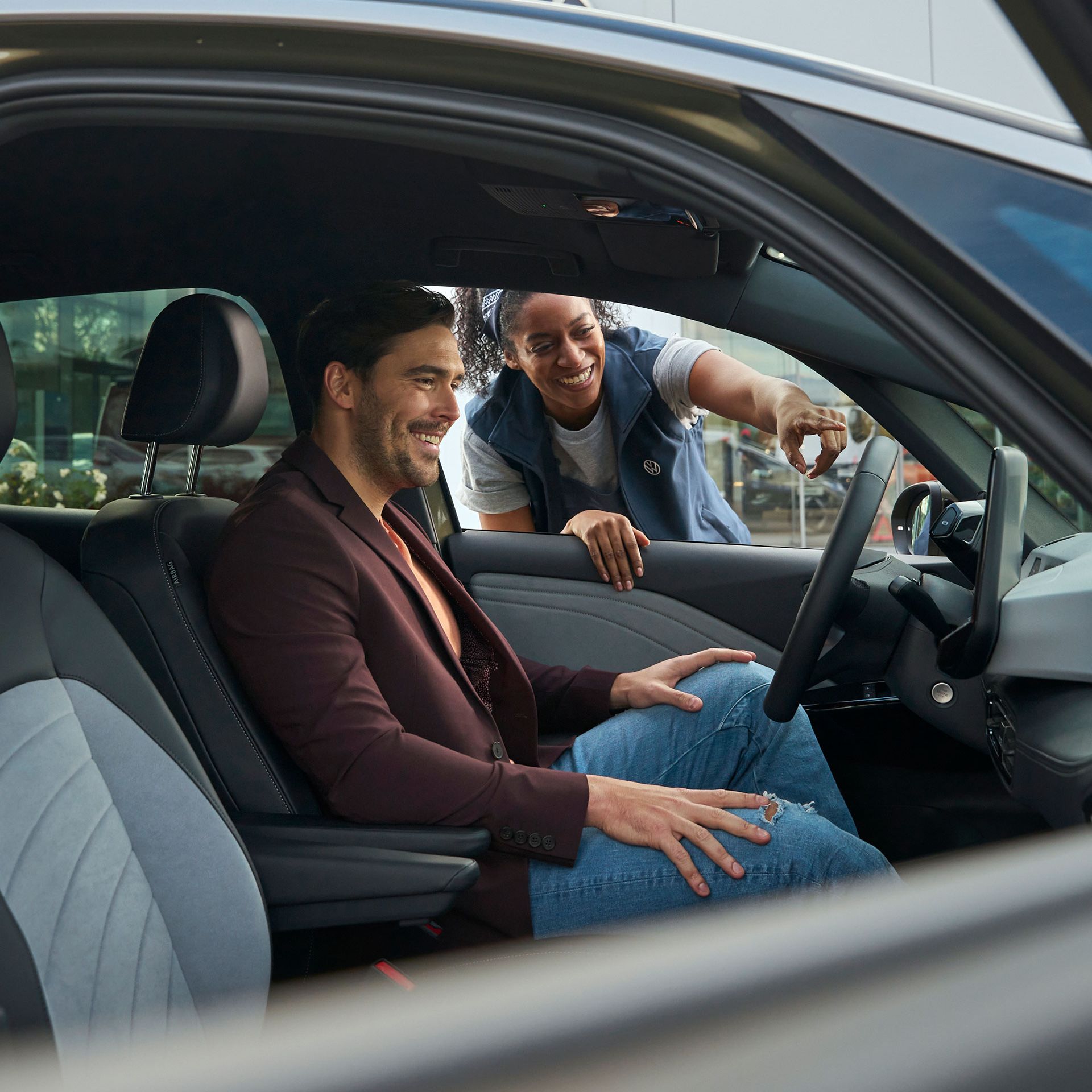 Eine Volkswagen Technikerin erklärt einem Kunden das Display in einem ID.