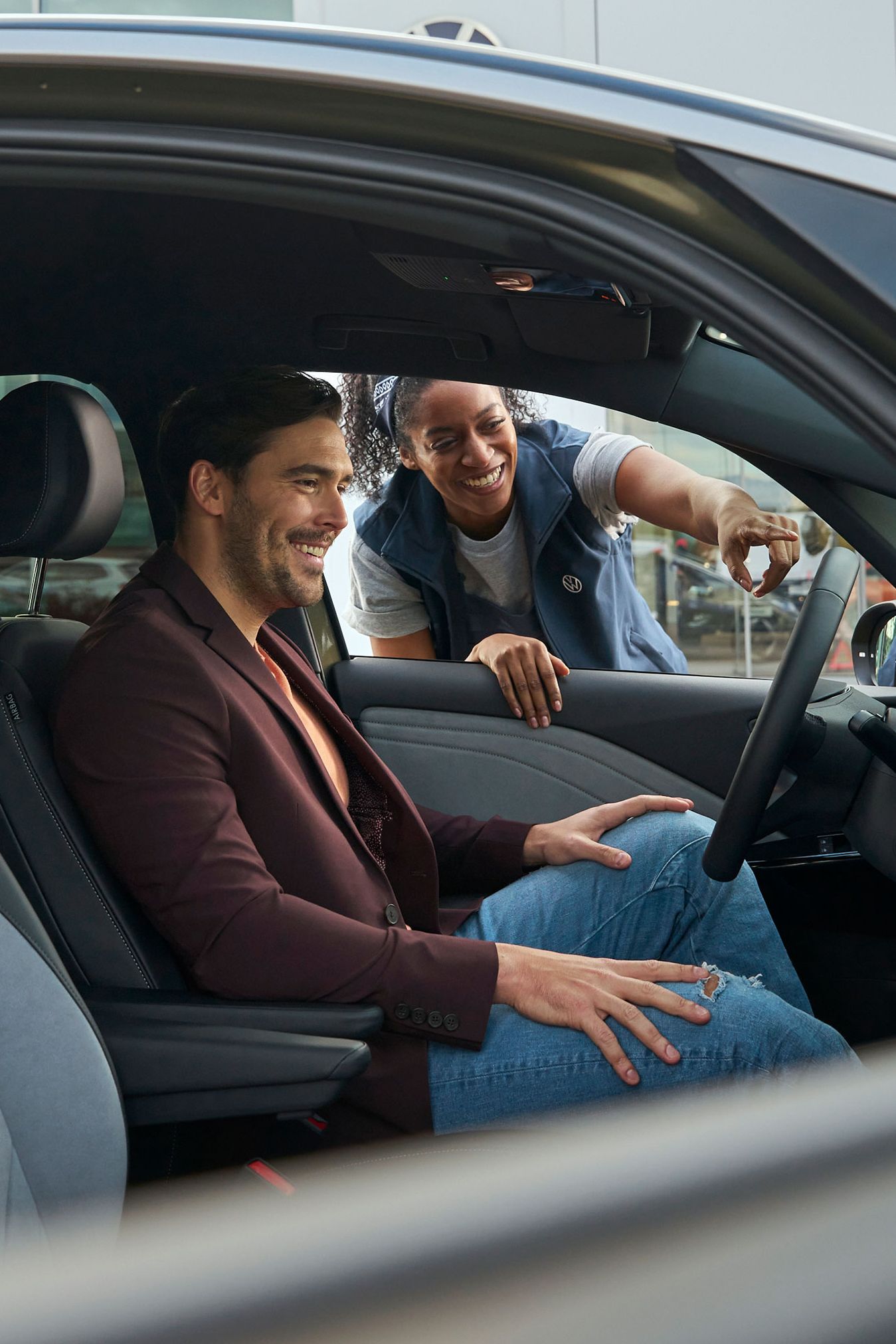 Eine Volkswagen Technikerin erklärt einem Kunden das Display in einem ID.