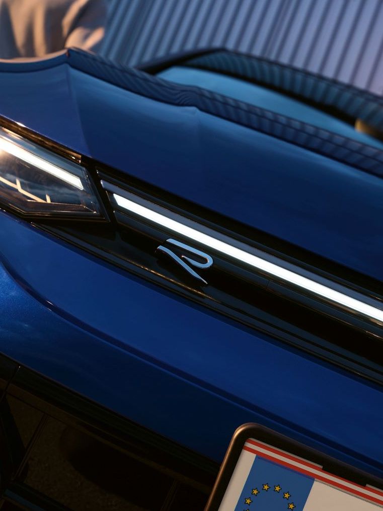 Golf R im Detailshot von der Vorderseite in schräger Ansicht mit Mann im Hintergrund.