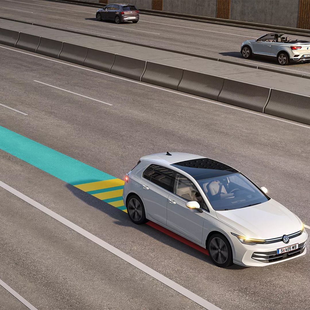 Бял Volkswagen Golf с активиран адаптивен автопилот на магистрала