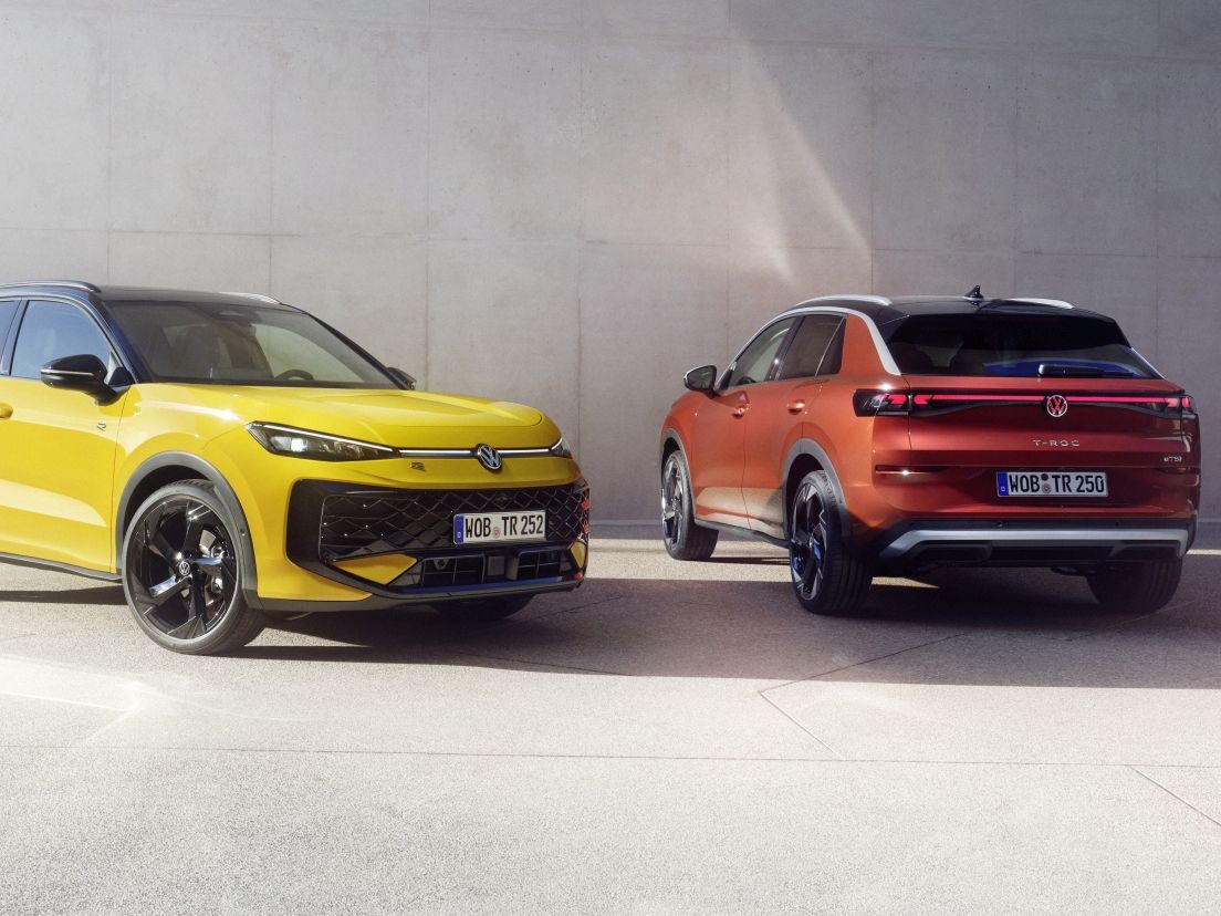 Жълт и оранжев Volkswagen T-Roc паркирани пред модерна сграда