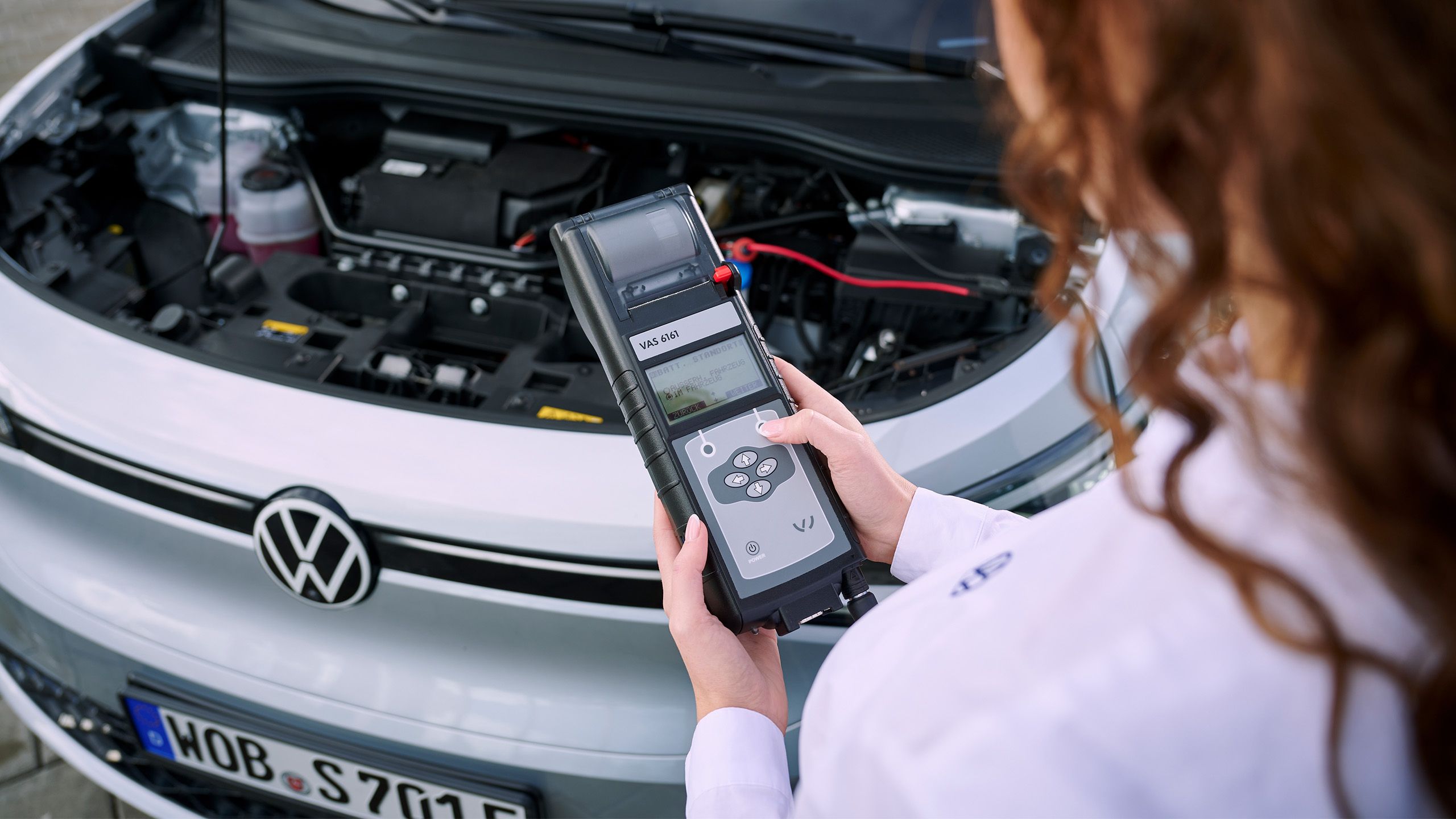 Eine VW Technikerin beim Elektroautoservice für einen Volkswagen ID