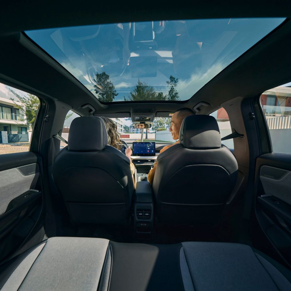 Поглед от задната седалка към предните седалки на VW ID. Cross, където двама души седят и разговарят.
