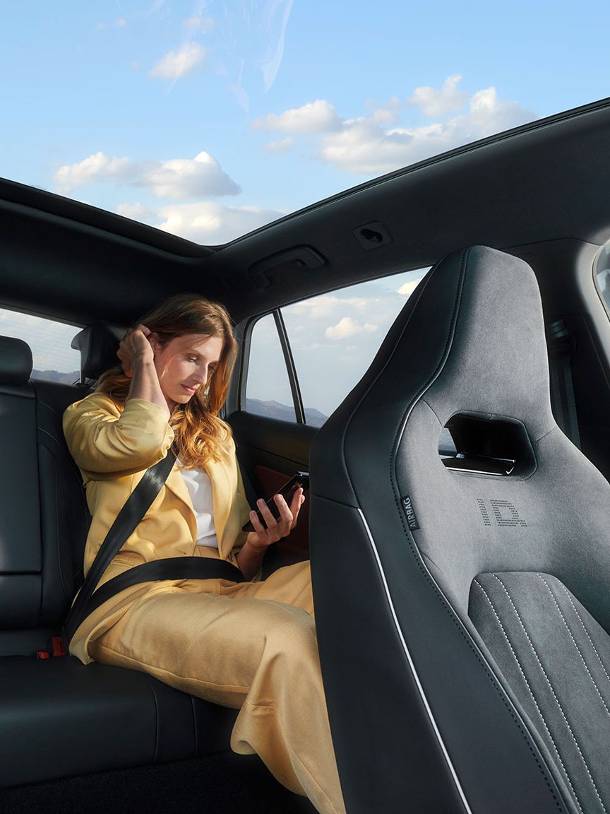 Жена пътува на задната седалка на Volkswagen ID., наслаждавайки се на панорамния покрив.