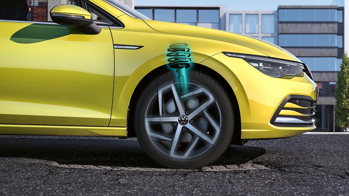 Жълт Volkswagen Golf с визуализация на адаптивното окачване при преминаване през неравности на пътя
