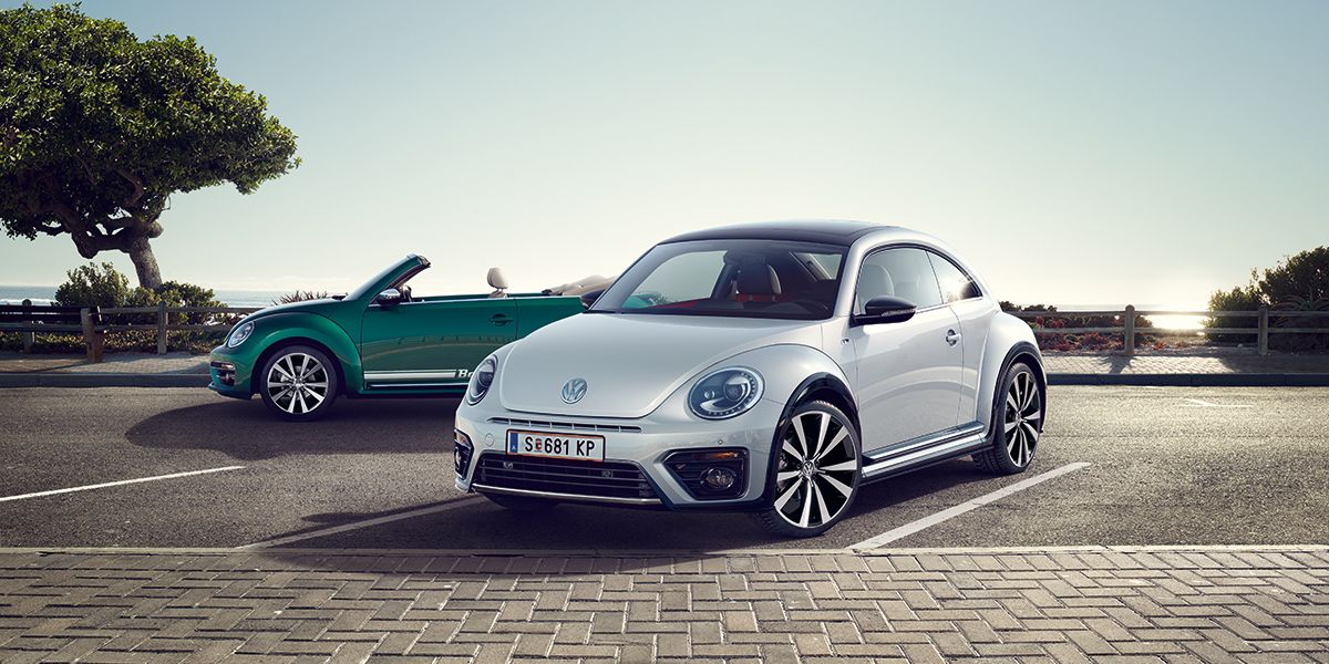 Два автомобила Volkswagen Beetle – кабриолет и купе, паркирани край морски бряг.