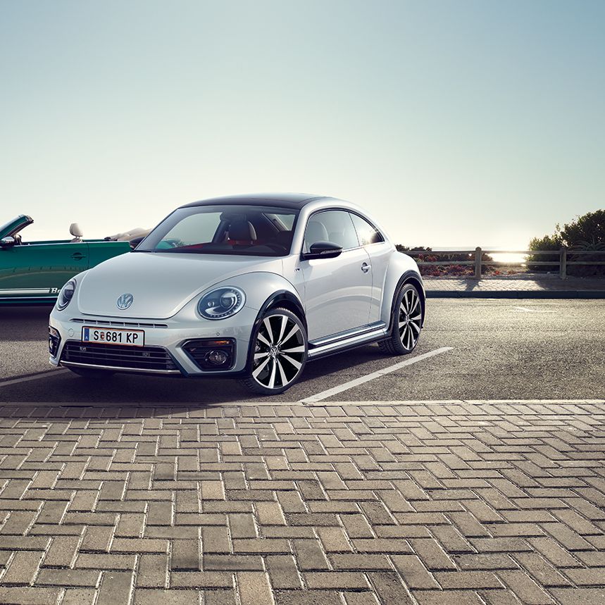 Два автомобила Volkswagen Beetle – кабриолет и купе, паркирани край морски бряг.