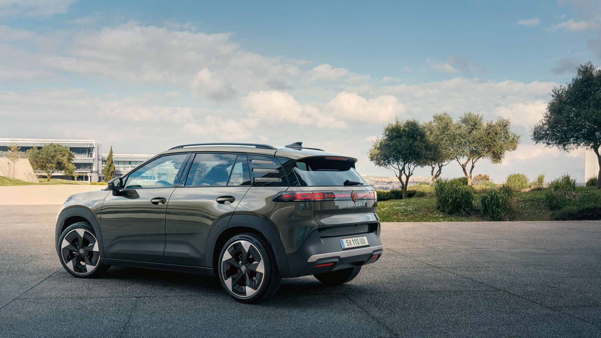 Изглед отзад на зелен VW ID. Cross, паркиран на площад със зелени дървета.