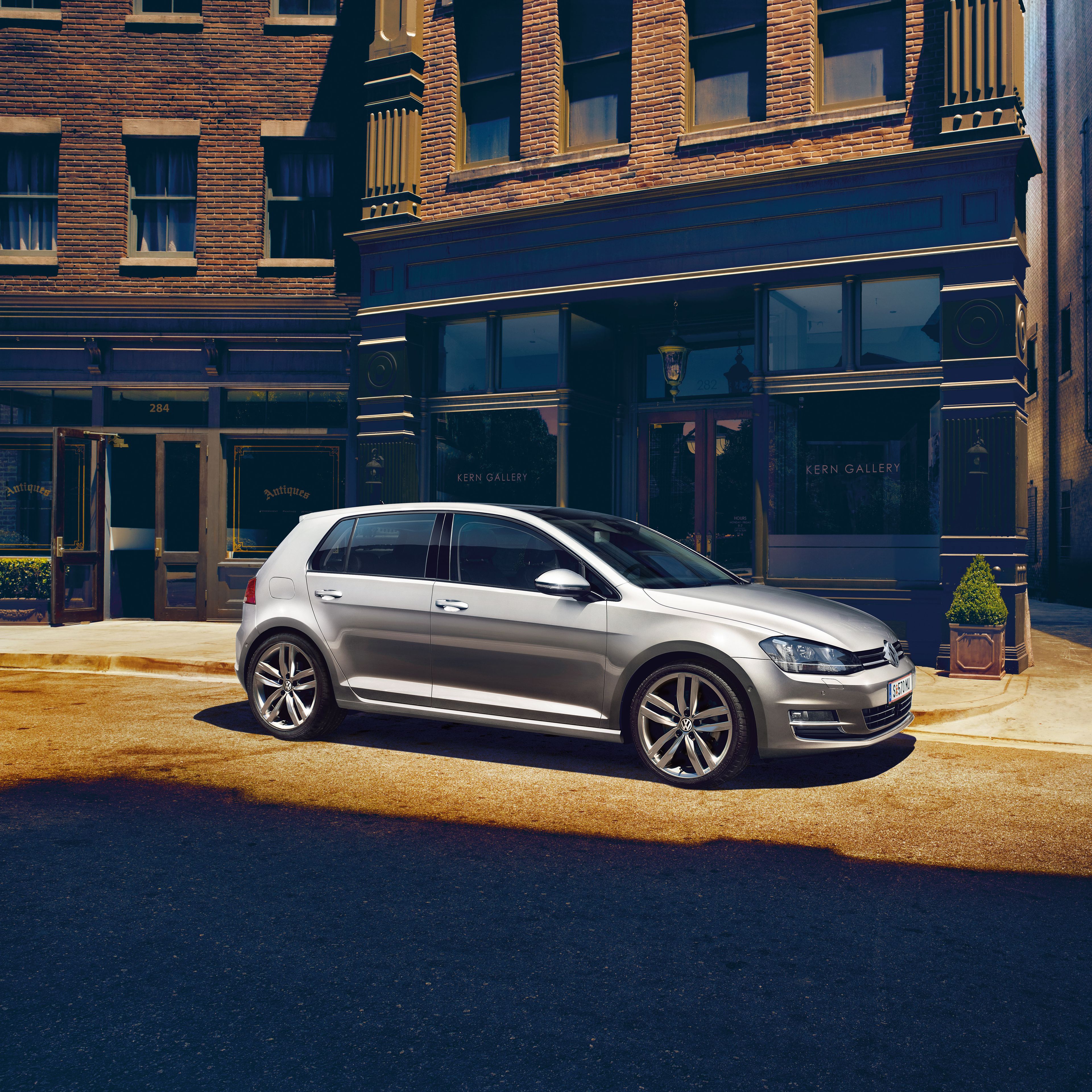 Сребрист Volkswagen Golf, паркиран пред стилна сграда в градска атмосфера