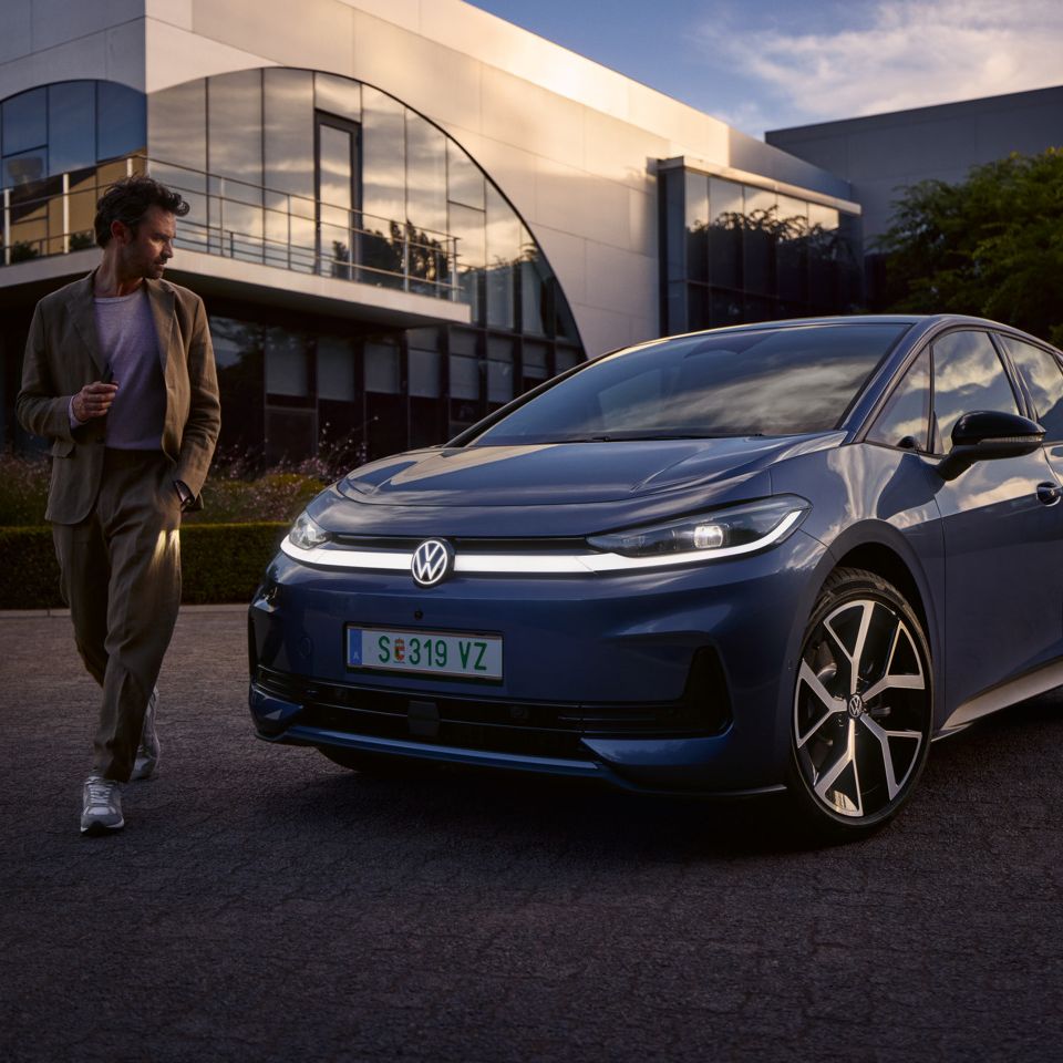 Мъж обикаля предната част на син VW ID.3 Neo и разглежда осветлението