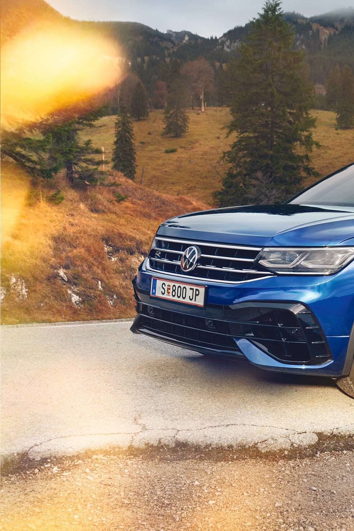 Син VW SUV Tiguan R странично пред планински пейзаж