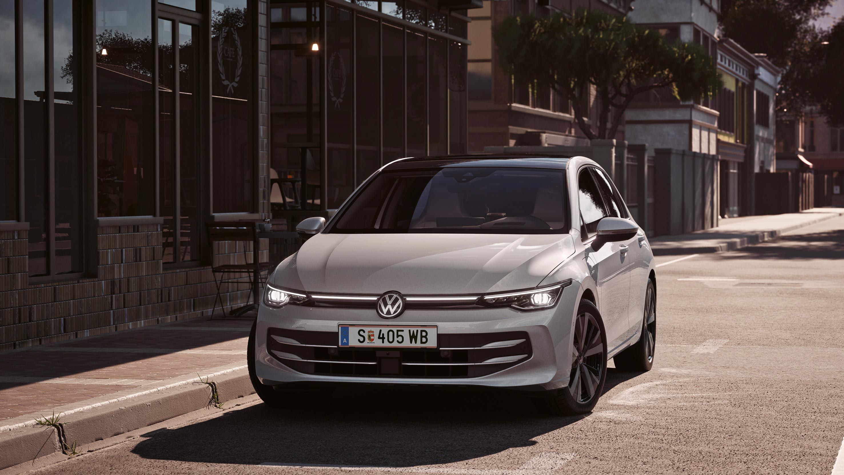Ein weißer VW Golf von parkt seitlich vor einem Restaurant. Zwei Männer gehen in Richtung des Wagens.