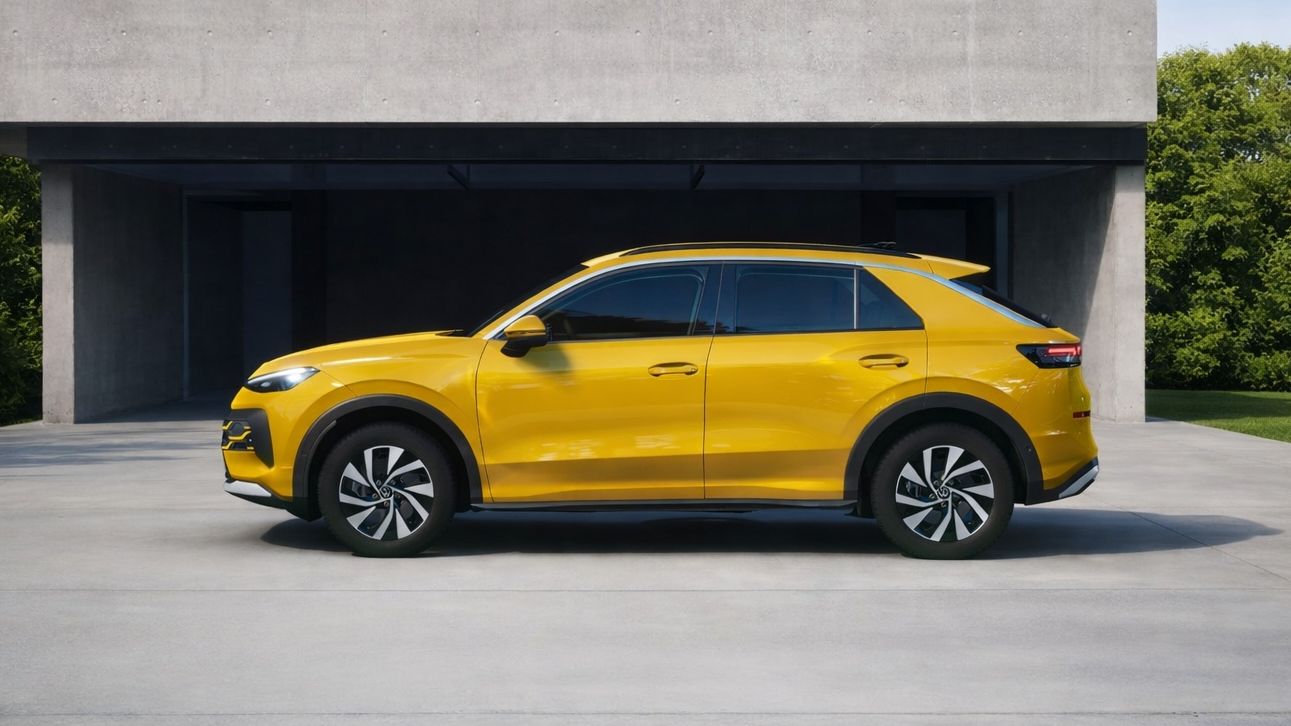 Жълт T-Roc тип SUV е паркиран на бетонна площадка пред модерна сграда с минималистичен дизайн. Зад автомобила се вижда зелена растителност. Небето е ясно и слънчево.