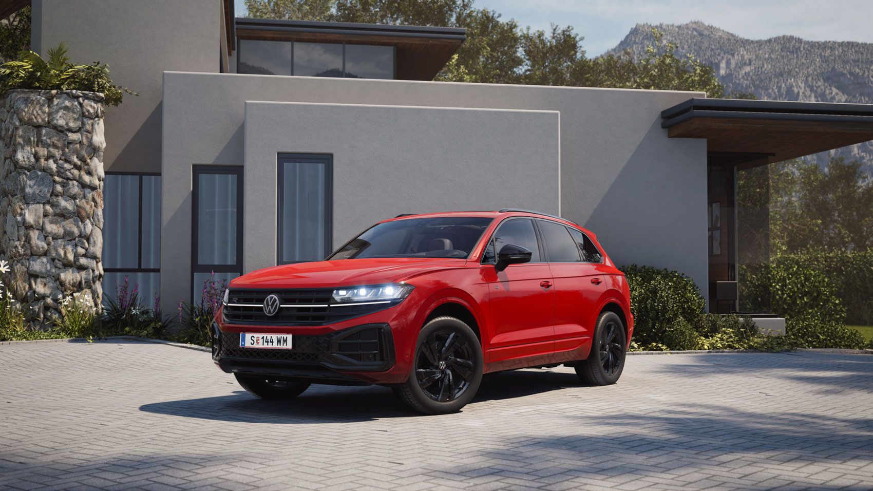Изглед отпред към страничната част на червен VW Touareg с елементи от R-Line "Exterior Black Style".