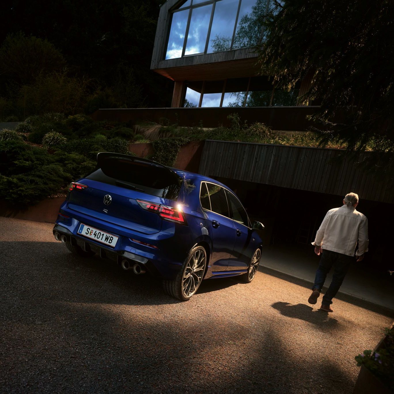 Golf R befindet sich geparkt vor einer Garage, daneben geht ein Mann vorbei.