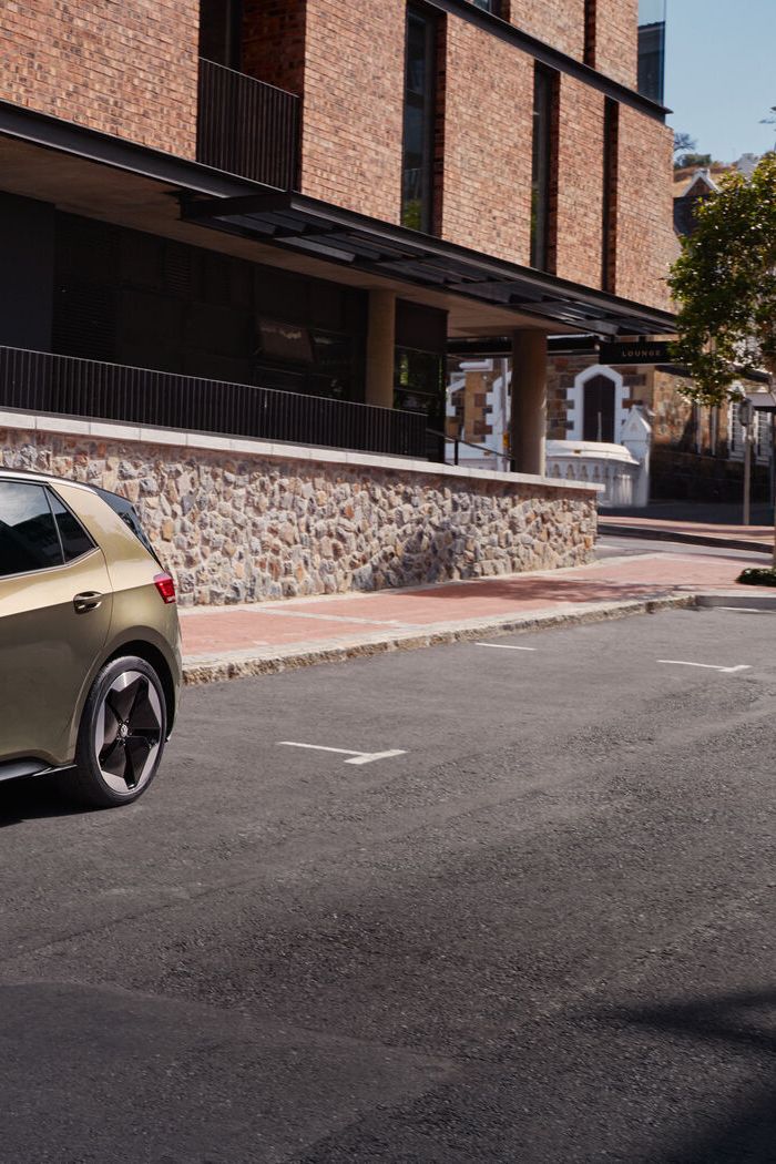 Поглед към VW ID.3 в цвят "Dark Olivine Green Metallic", паркиран отстрани на улица, до бордюра.