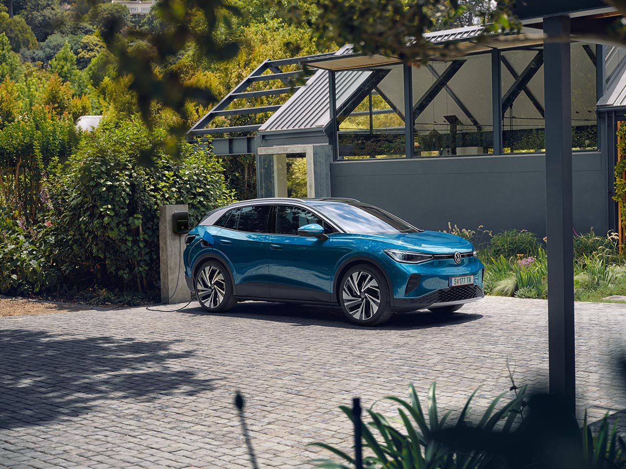 Син електрически Volkswagen ID.4, който се зарежда в домашна станция