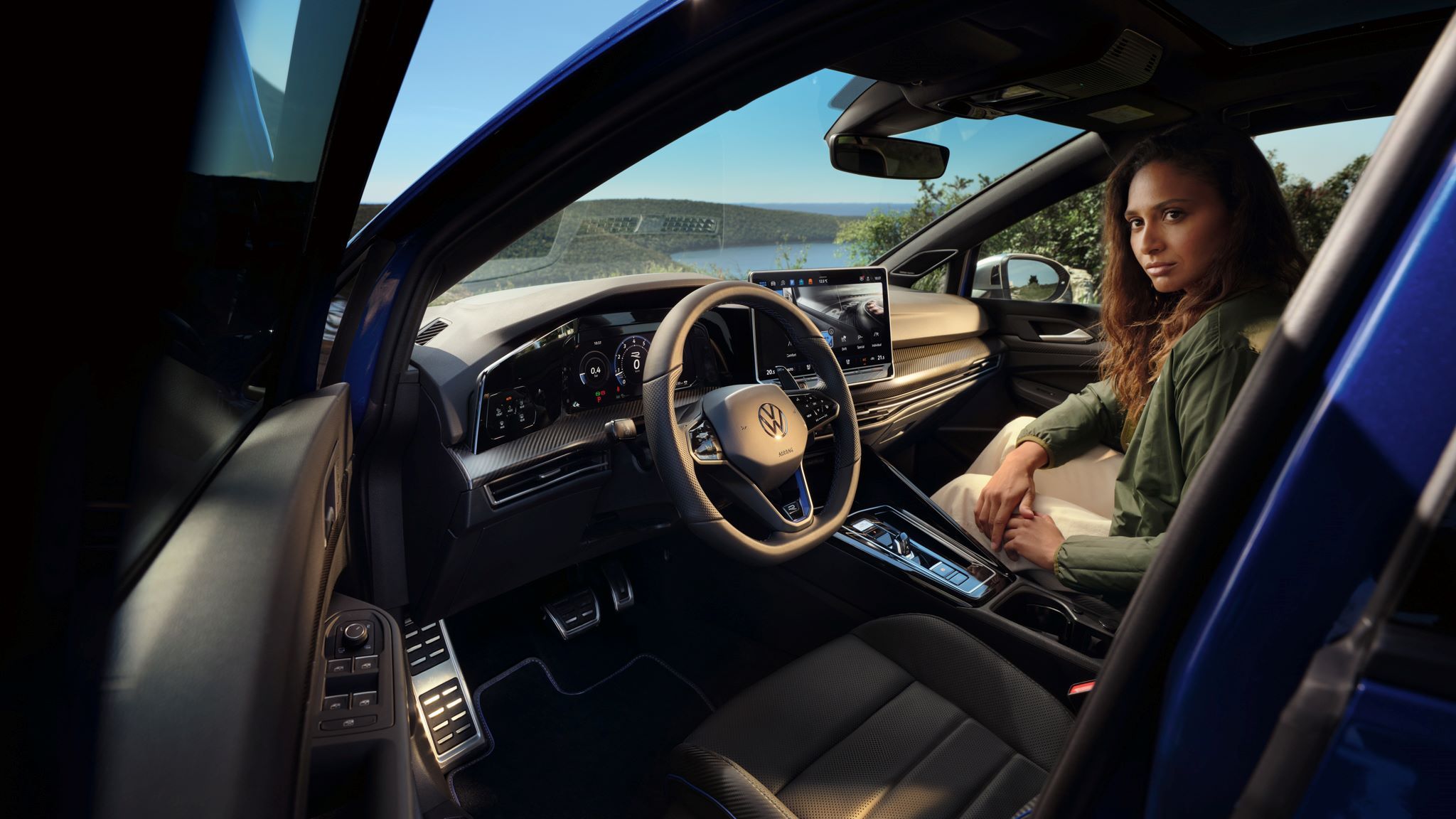Sicht von geöffneter Fahrertür auf das Interior des Golf R mit einer Frau, welche auf dem Beifahrersitz ist.