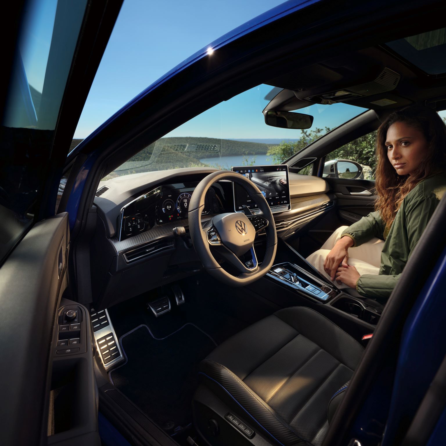 Sicht von geöffneter Fahrertür auf das Interior des Golf R mit einer Frau, welche auf dem Beifahrersitz ist.