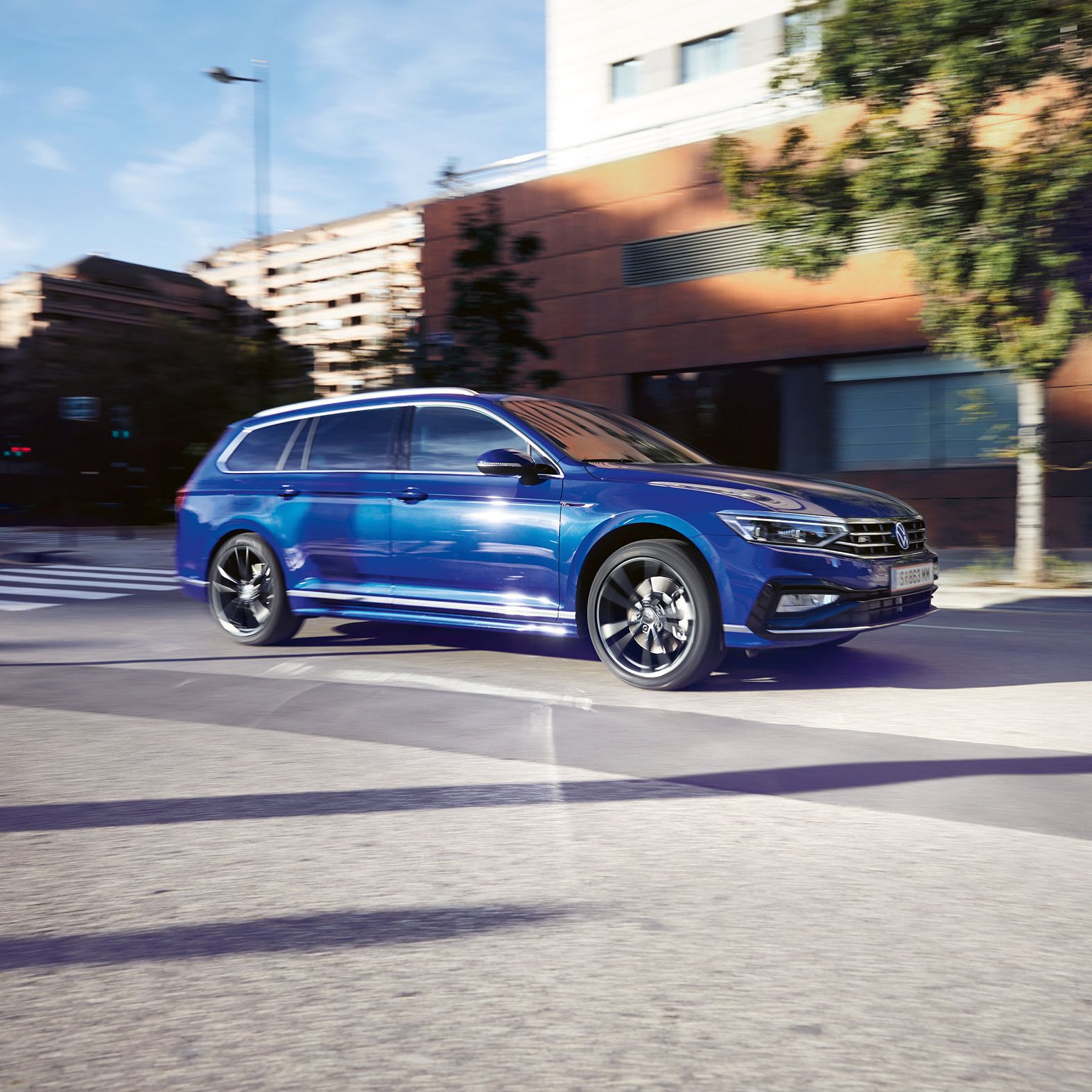 Син Volkswagen Passat Variant в движение по градска улица