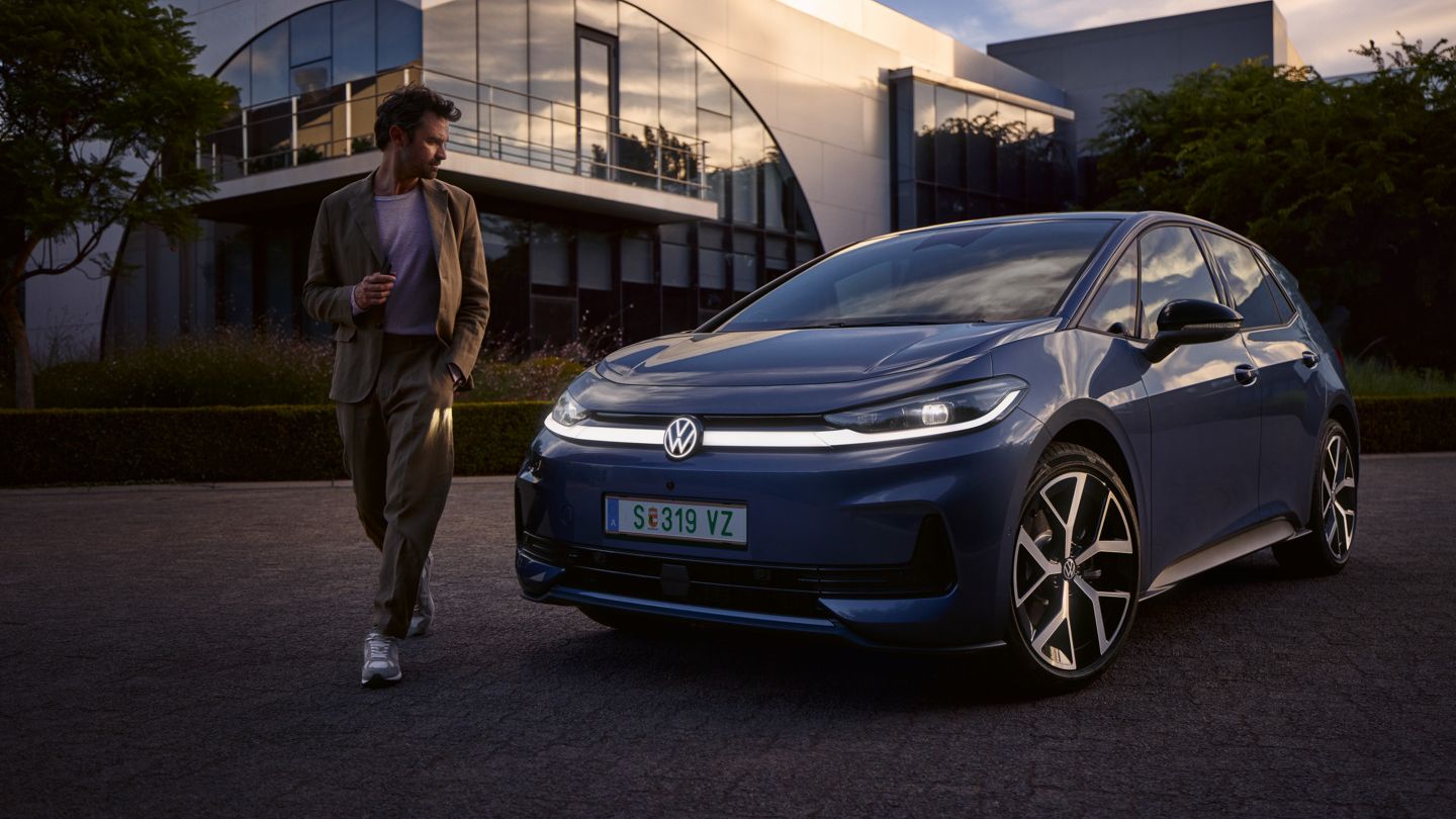 Мъж обикаля предната част на син VW ID.3 Neo и разглежда осветлението