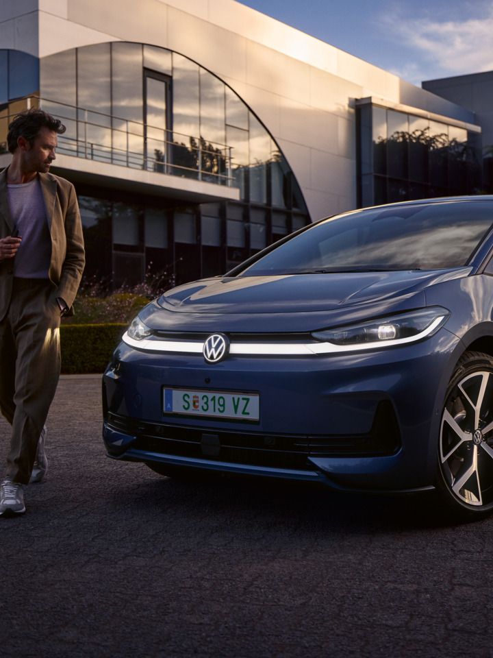 Мъж обикаля предната част на син VW ID.3 Neo и разглежда осветлението