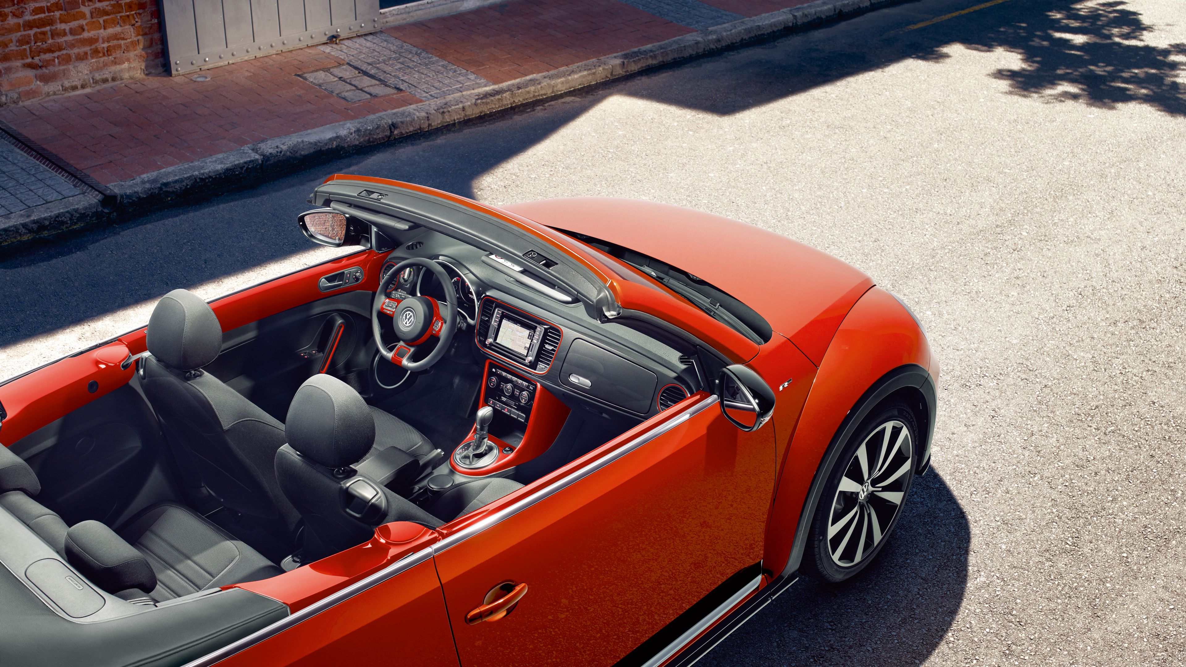 Отворен покрив и модерен интериор на оранжев Volkswagen Beetle Cabriolet, сниман отгоре