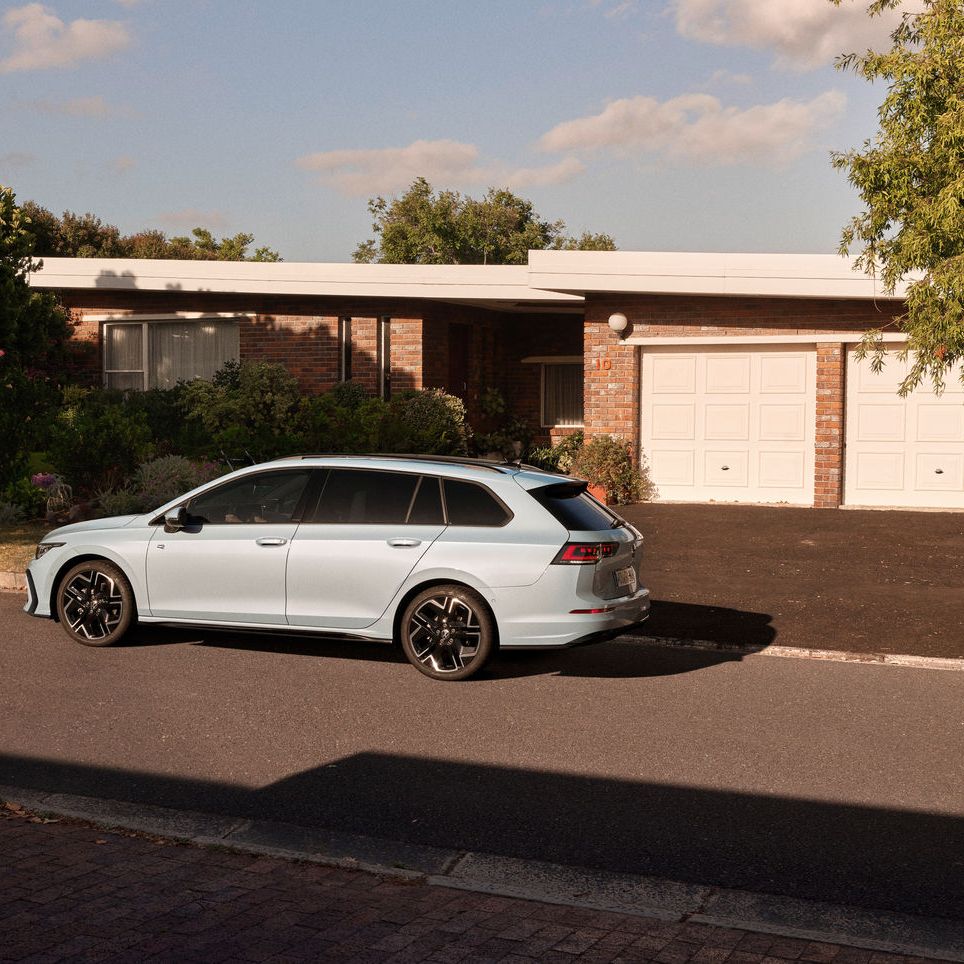 Светъл Volkswagen Golf Variant паркиран пред къща с гараж и зелена градина