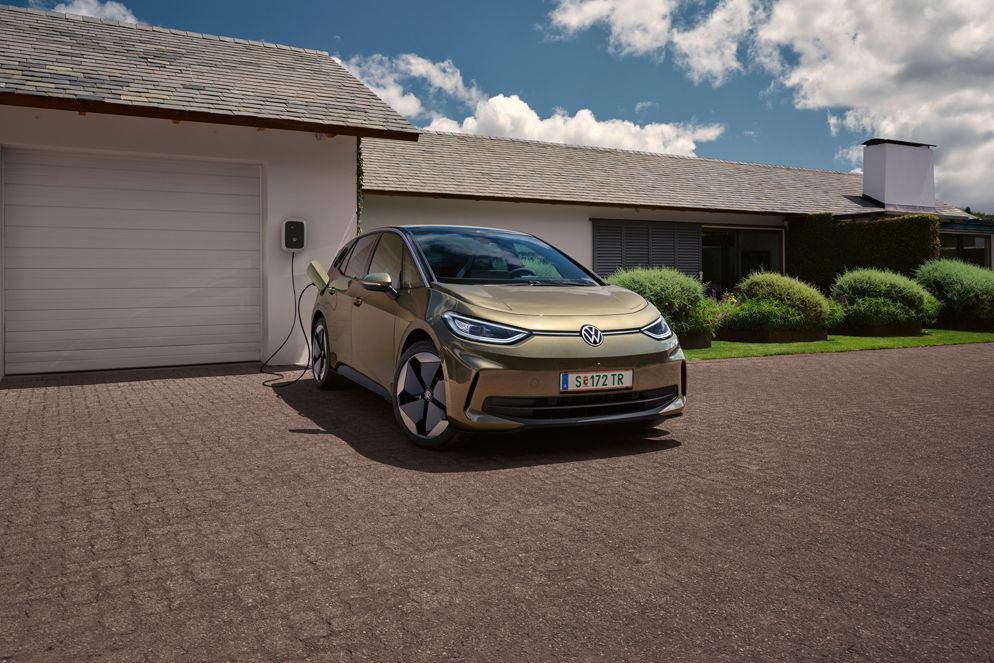 VW ID.3 in Weiß, Sicht auf Front mit Scheinwerfern und optionalen Felgen Andoya, Frau lehnt an Auto.