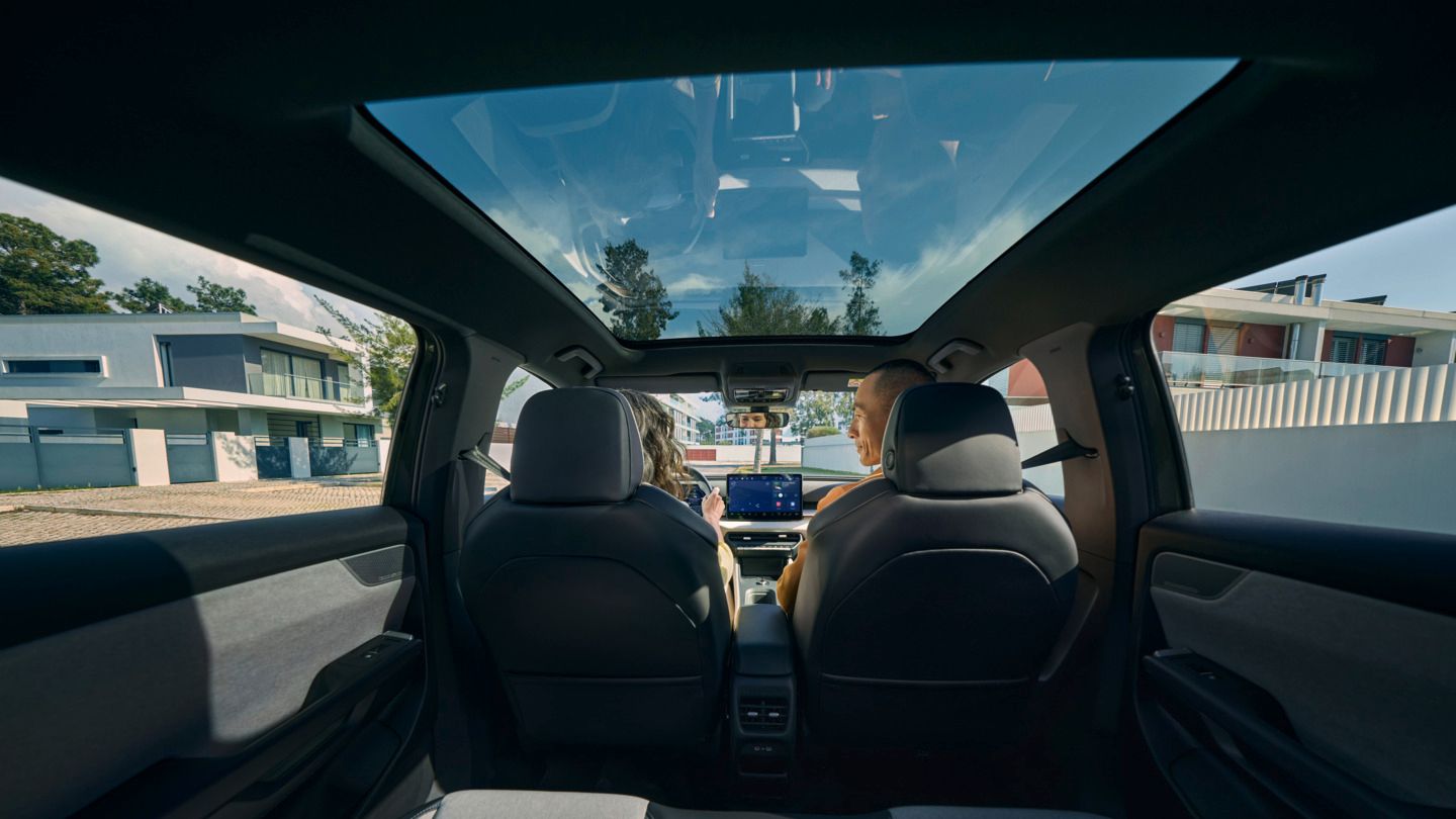 Поглед от задната седалка към предните седалки на VW ID. Cross, където двама души седят и разговарят.