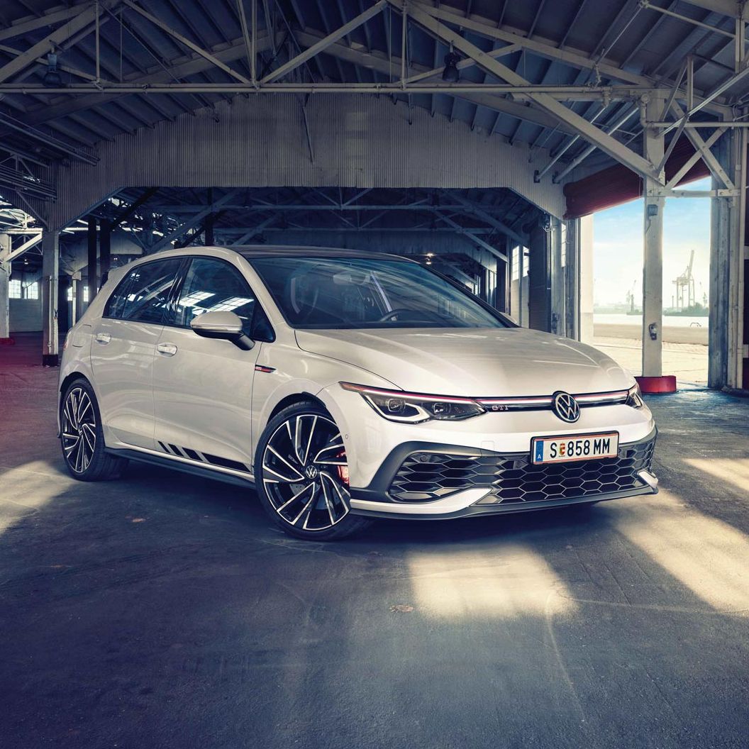 Бял Volkswagen Golf GTI, заснет отпред в индустриално хале с падаща естествена светлина