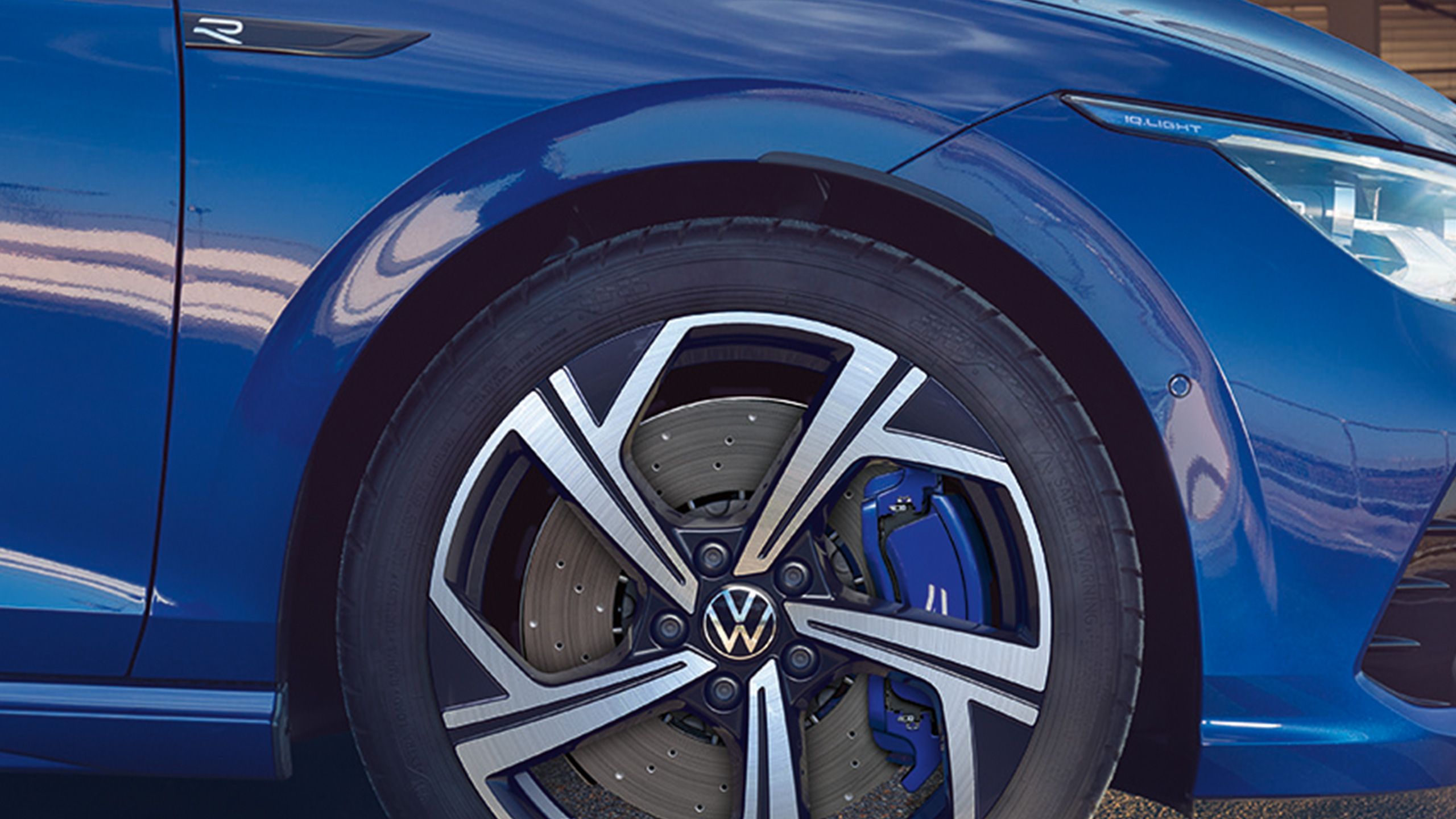 Близък план на джанта и синя спирачна система на син Volkswagen Golf R