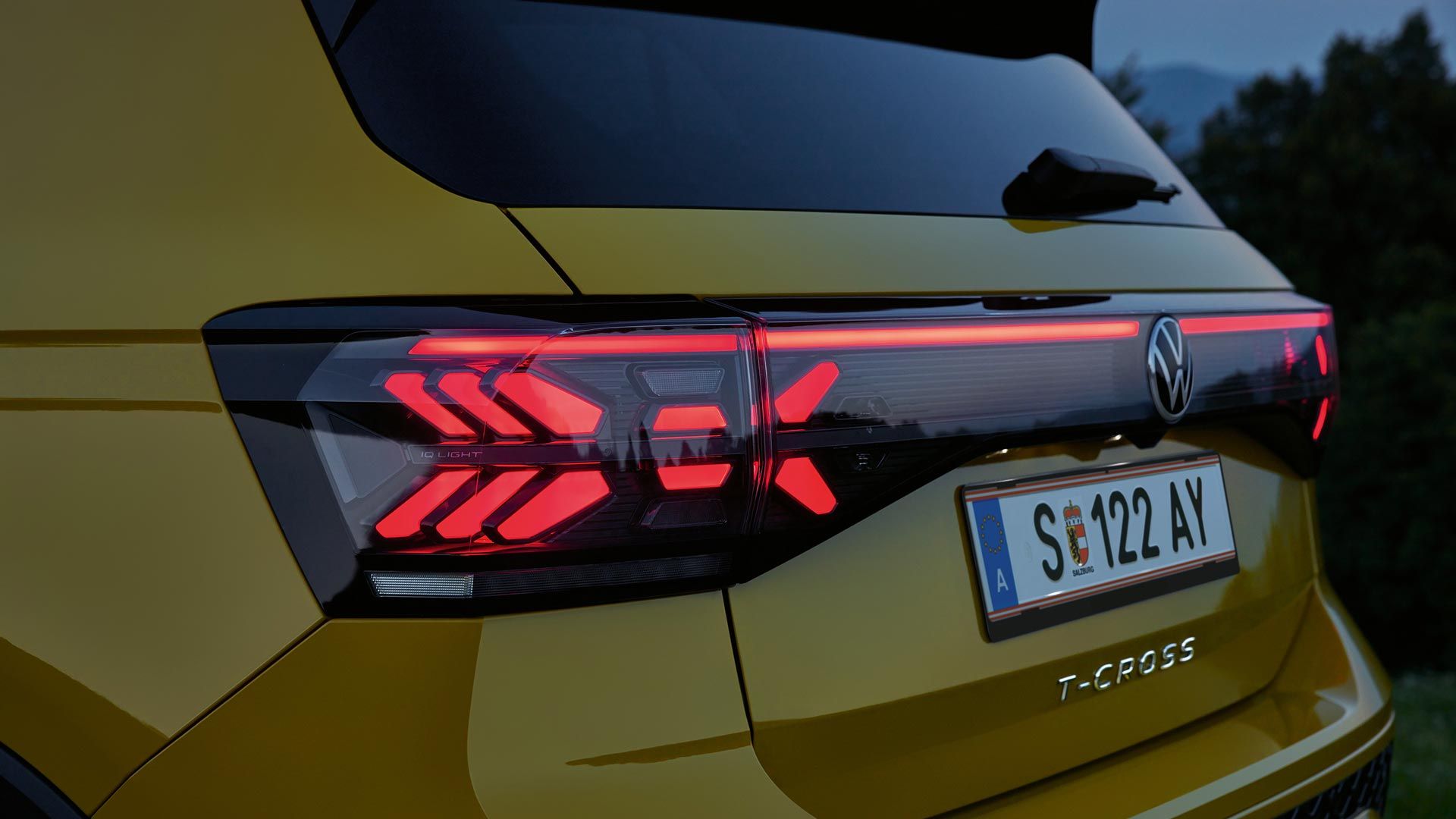 Задните светлини на жълт VW T-Cross отблизо привечер.