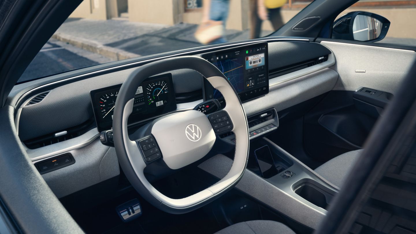 Изглед през отворената врата на шофьора към кокпита на VW ID. Polo Style, който е паркиран край пътя.