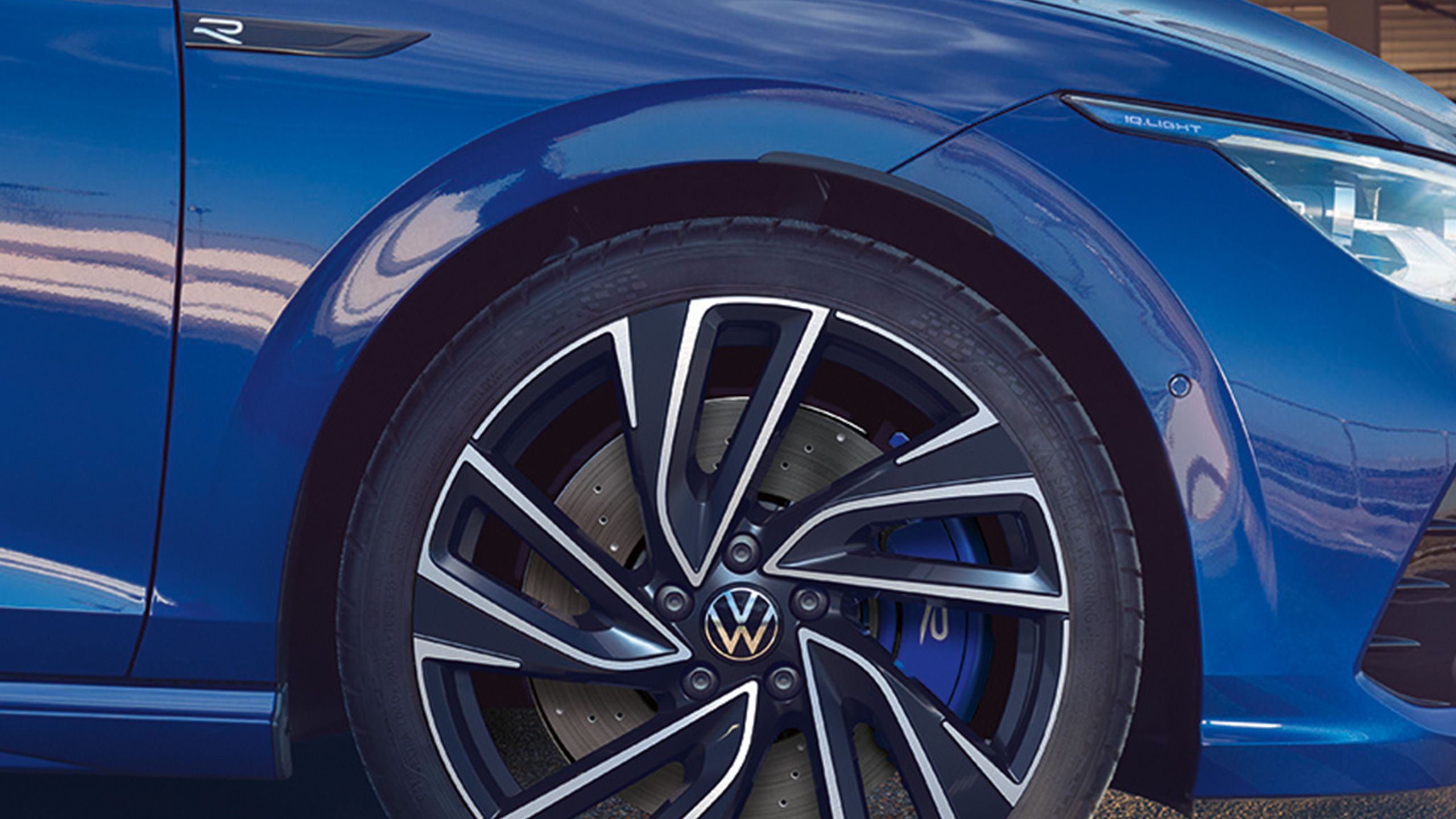 Близък план на алуминиев джант и спирачна система на син Volkswagen Golf R