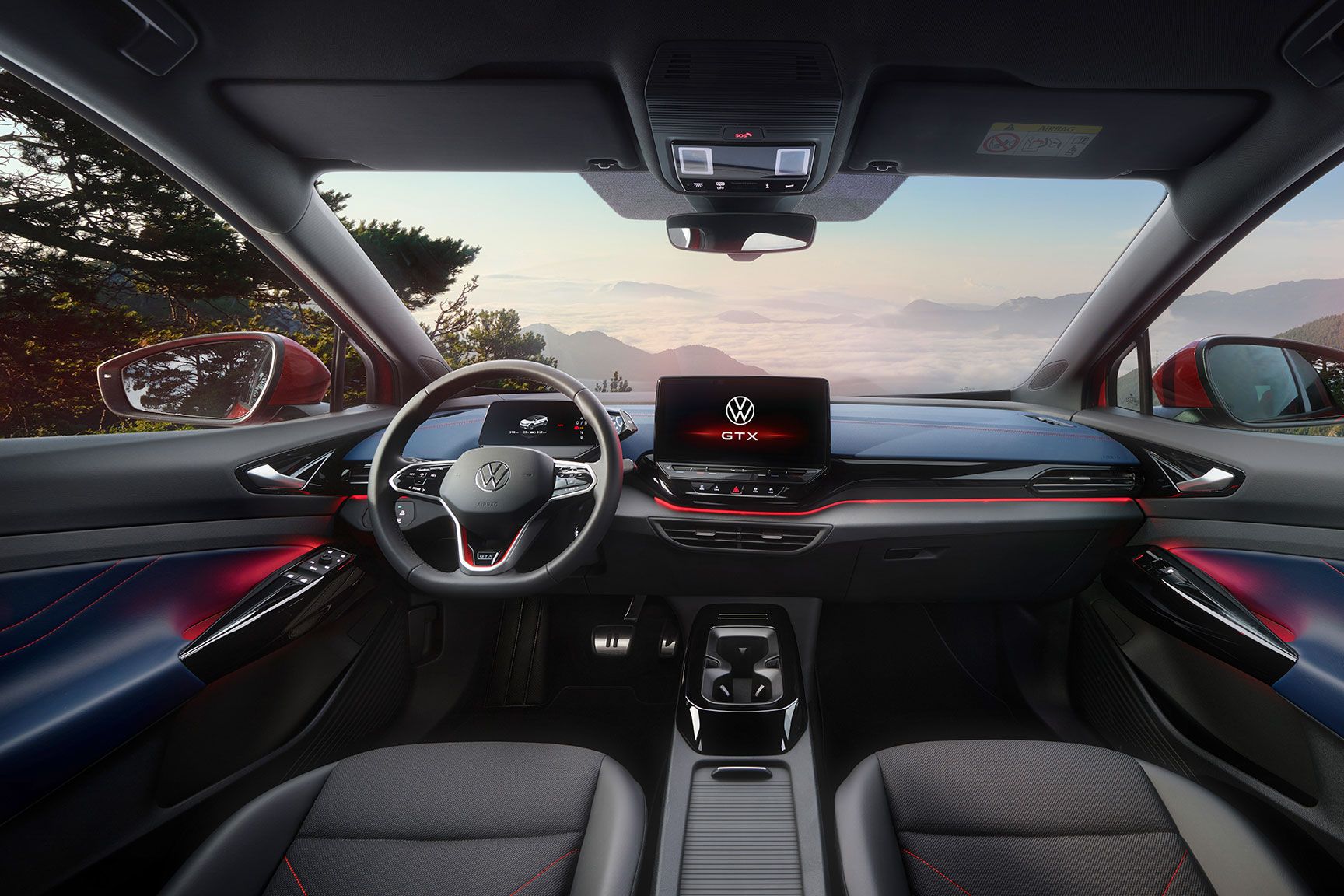 Innenraum von einem roten VW ID.5 GTX. Blick auf Lenkrad, Display, Sitze, Armaturen und Rückspiegel.