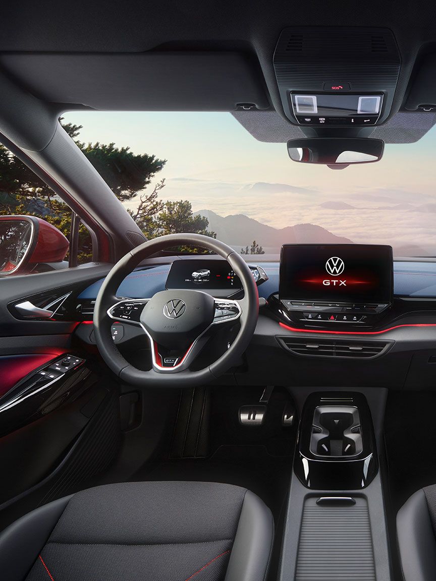 Innenraum von einem roten VW ID.5 GTX. Blick auf Lenkrad, Display, Sitze, Armaturen und Rückspiegel.
