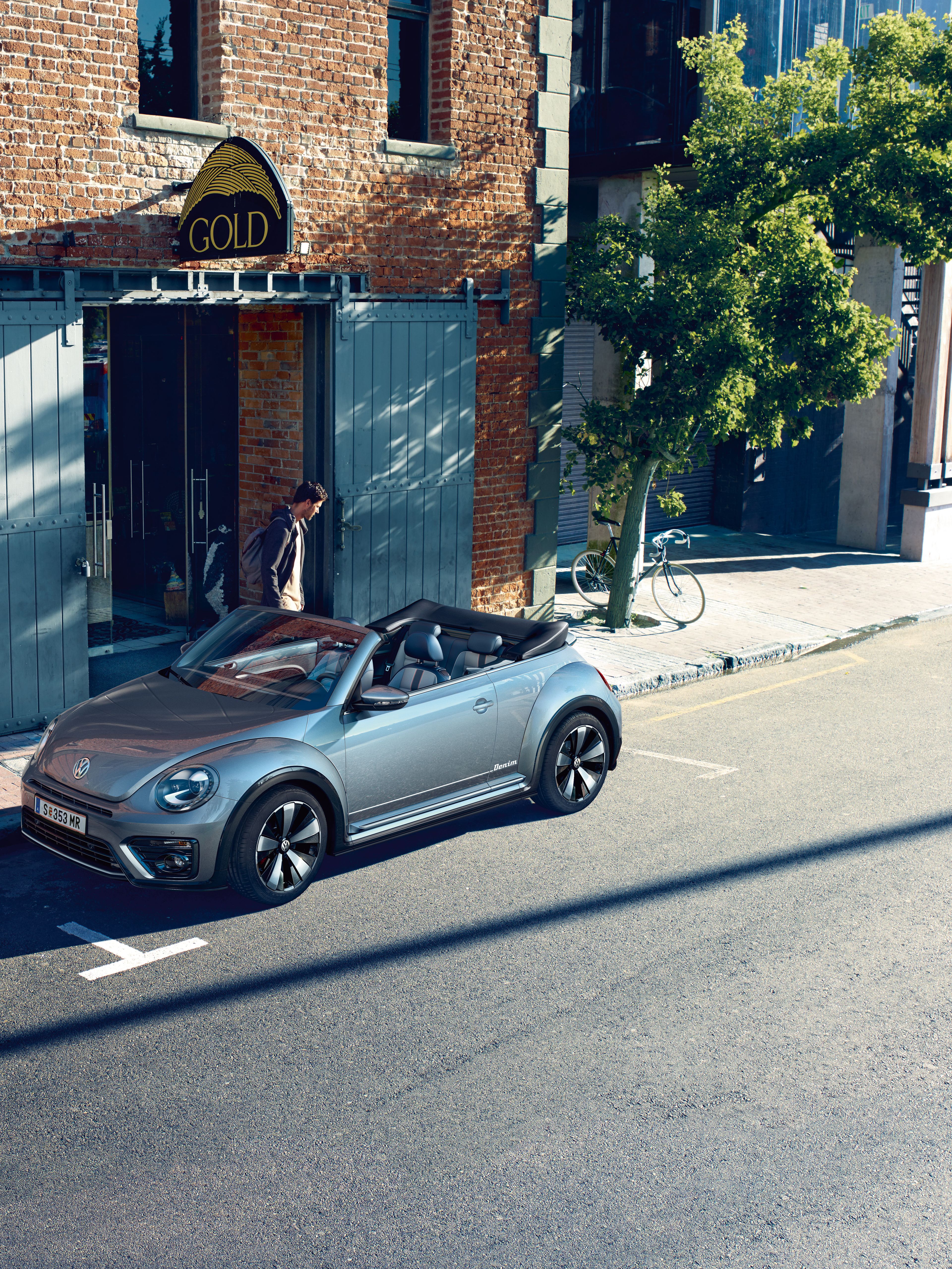 Сив Volkswagen Beetle кабриолет паркиран пред тухлена сграда в градска среда