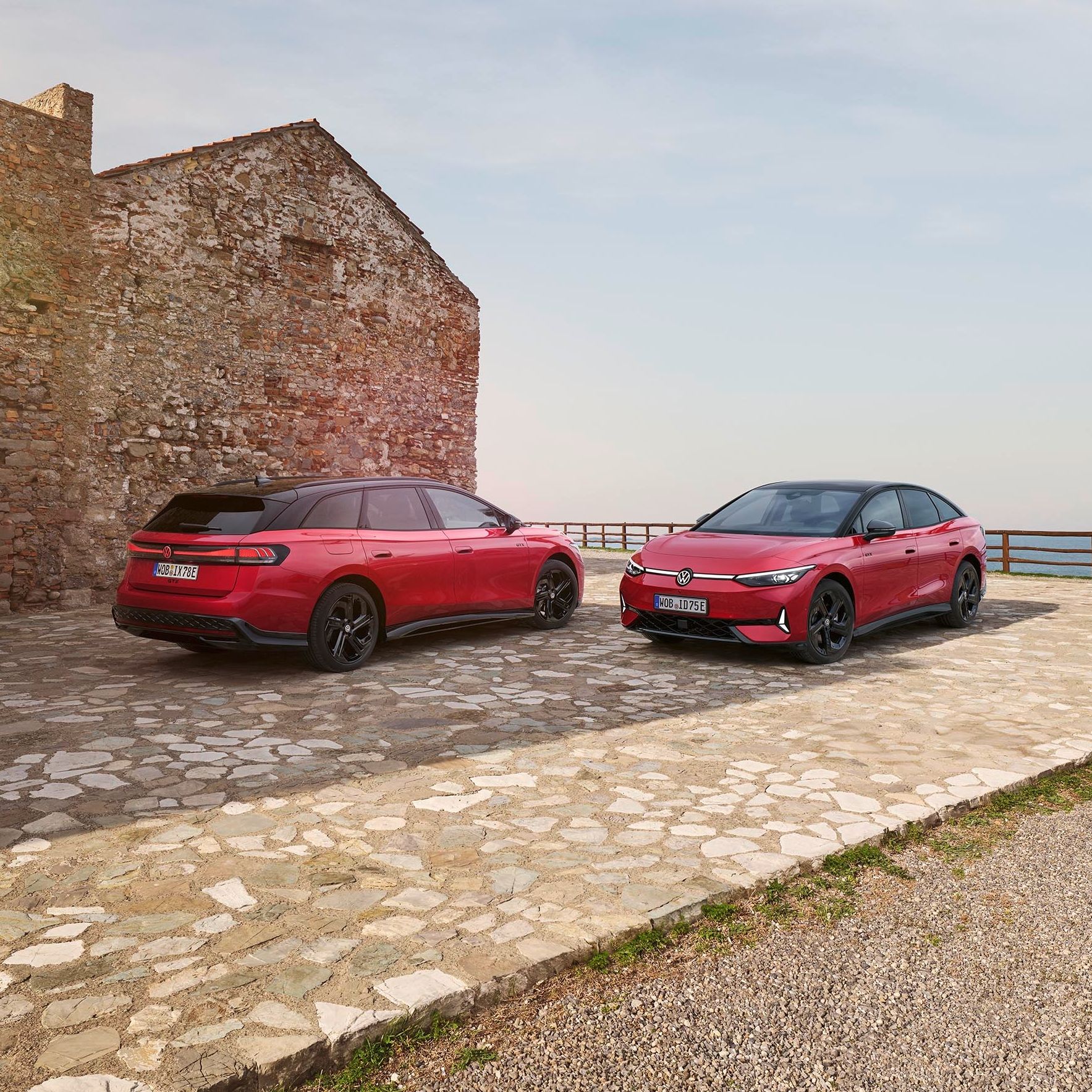 Два червени електрически модела Volkswagen ID.7 паркирани край морето