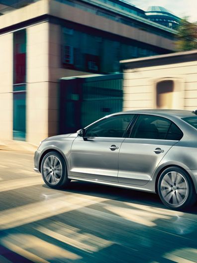 Сребрист Volkswagen Jetta в движение по градска улица